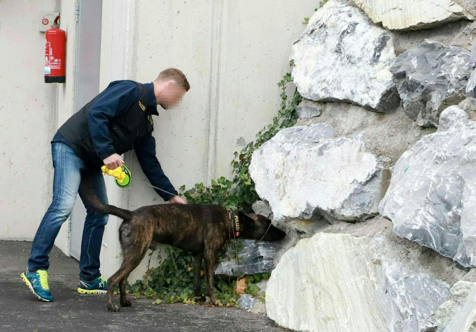 Ein Ermittler mit Spürhund vor dem Haus, in dem sich die Tat ereignete, aufgenommen am 21. Oktober 2018.