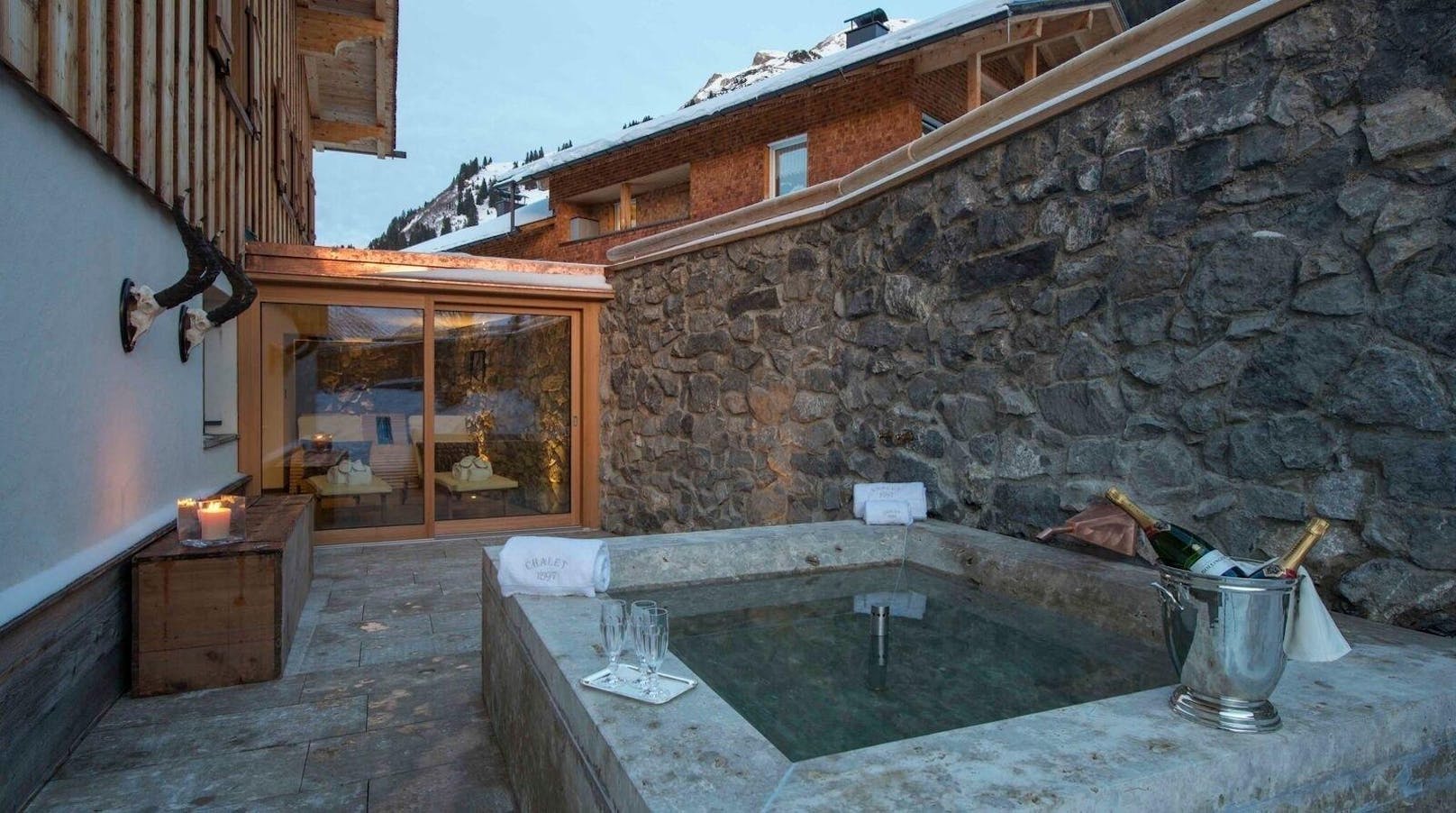 <b>Wohnlfühloase auf drei Etagen in Lech, Österreich</b>

Diese besondere Glanzstück alpiner Baukunst vereint rustikalen Charme mit luxuriösen Elementen. Sie verfügt über fünf Schlafzimmer, einen geräumigen Speisesaal, einen Wohnraum, eine hauseigene Bar und das exklusive Highlight einer Bio-Sauna. Der Platz reicht für zwölf Personen und die Einbettung in ein verträumtes Bergambiente bietet eine unvergessliche Atmosphäre. Der Preis pro Nacht beträgt 7.052 Euro.