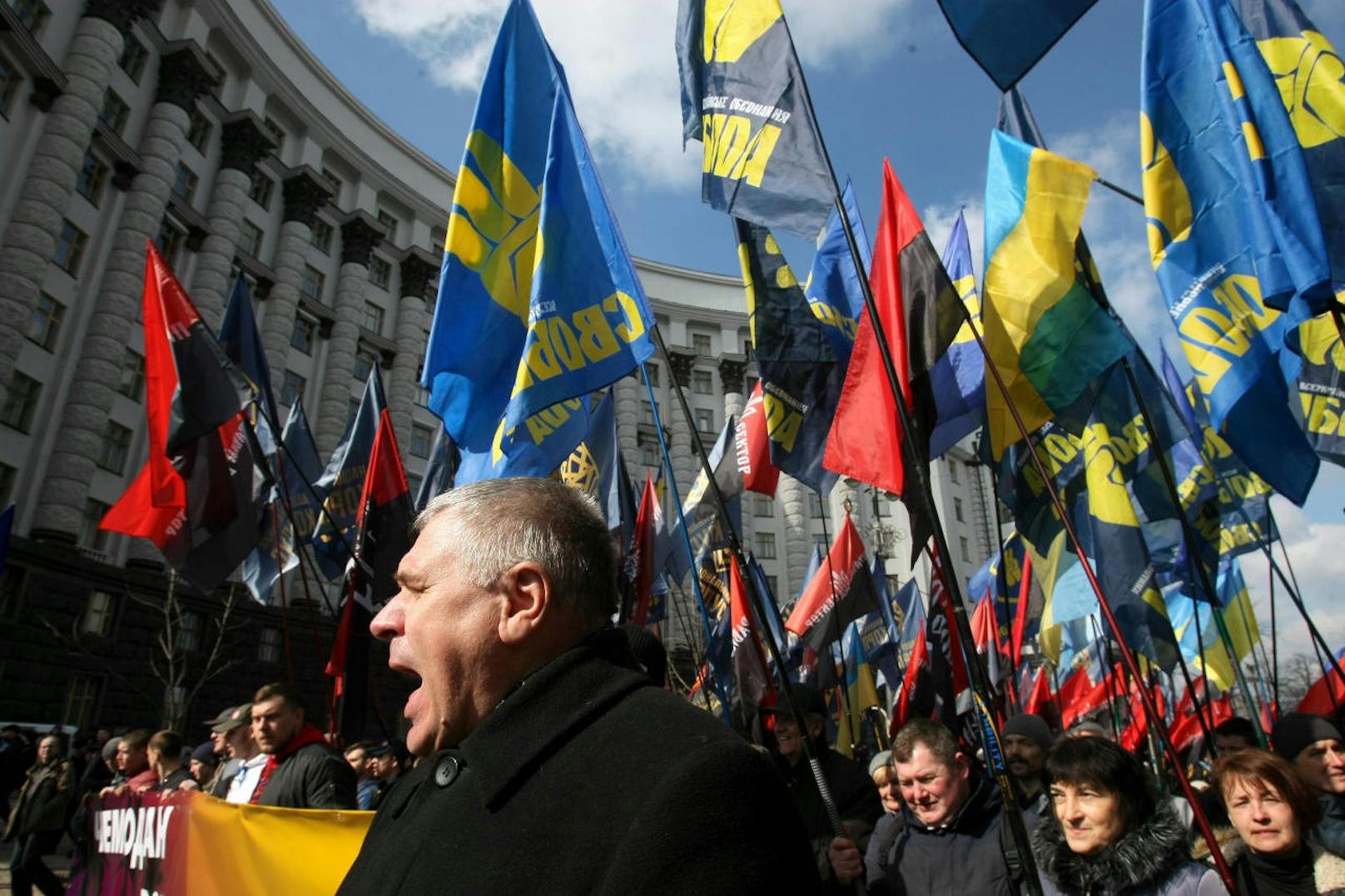 Rechte Demonstranten und Anhänger von nationalistischen Parteien marschieren mit Flaggen und Plakaten vor einem Regierungsgebäude in Kiew im April 2018.