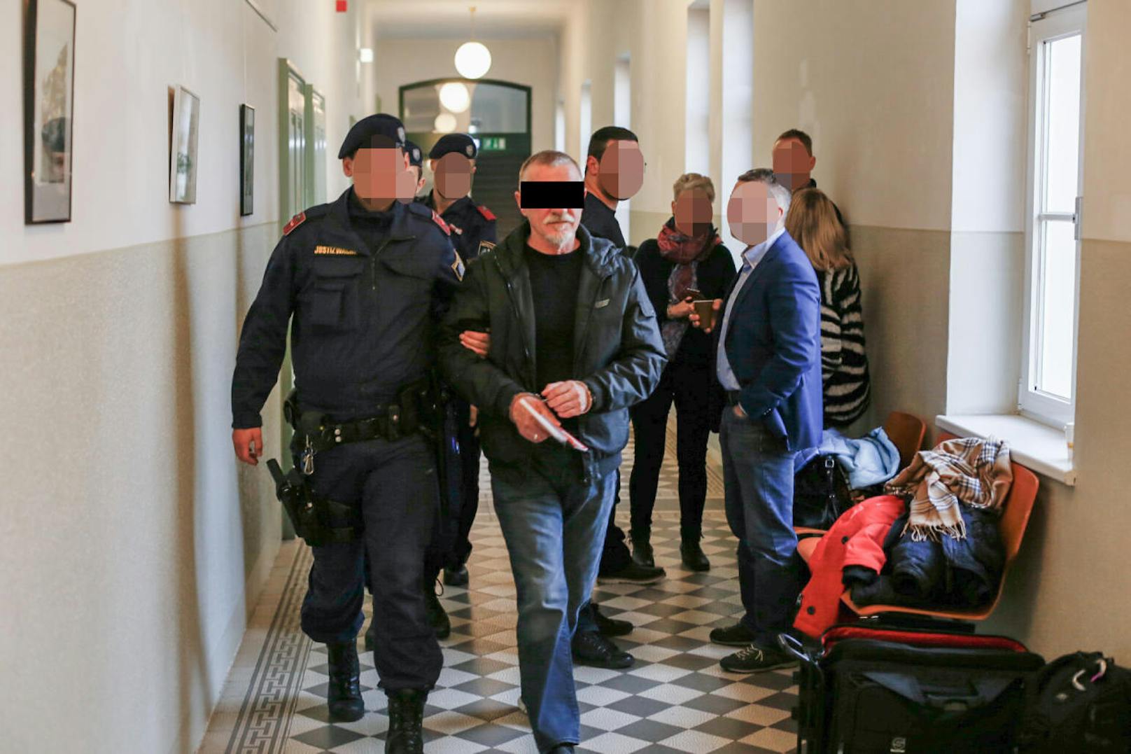 Branko B. wird begleitet von Justizwachebeamten durch das Gerichtsgebäude geführt.