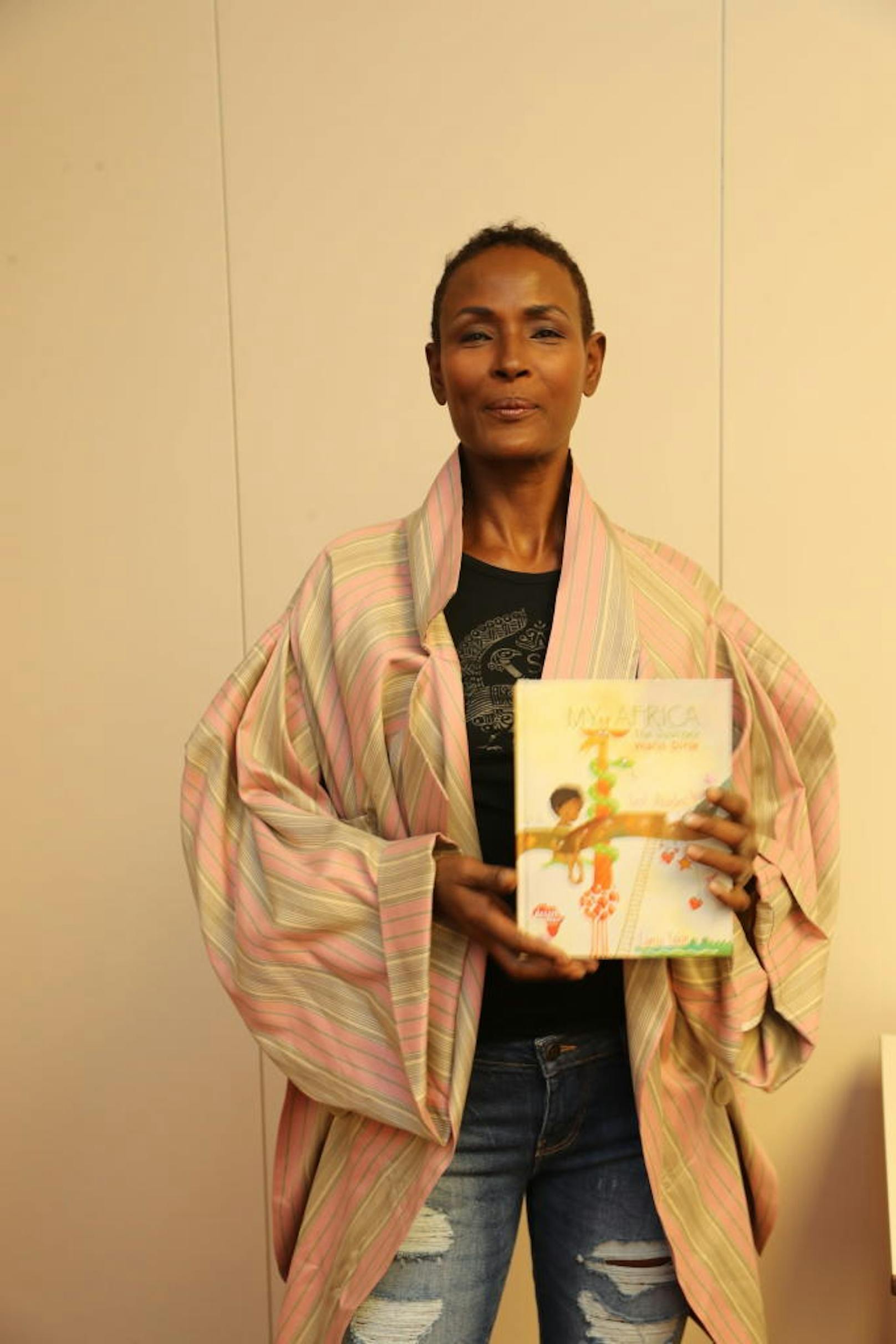 Dirie mit ihrem Lehrbuch für Afrikanische Kinder