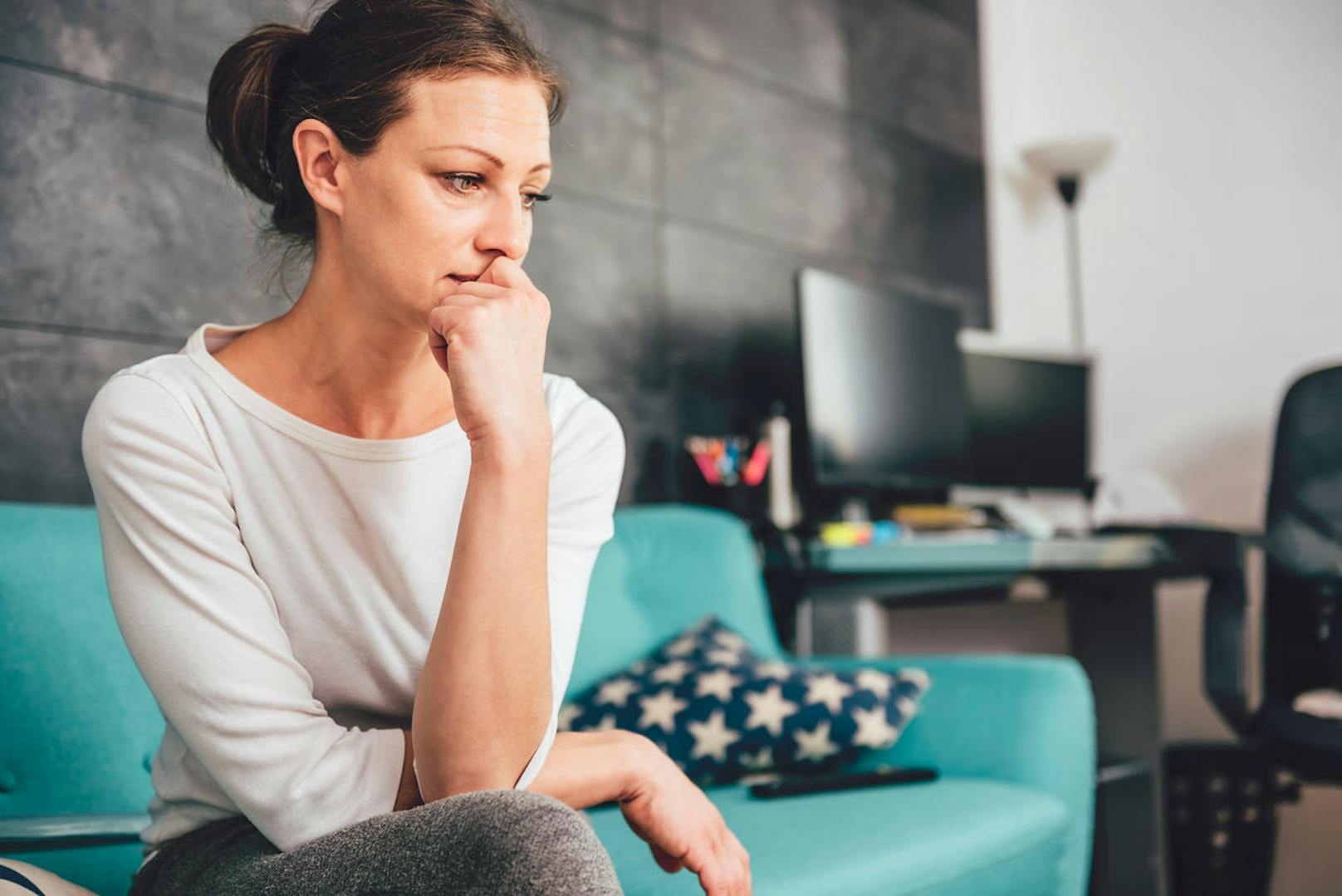 Sad woman sitting on a sofa in the living room