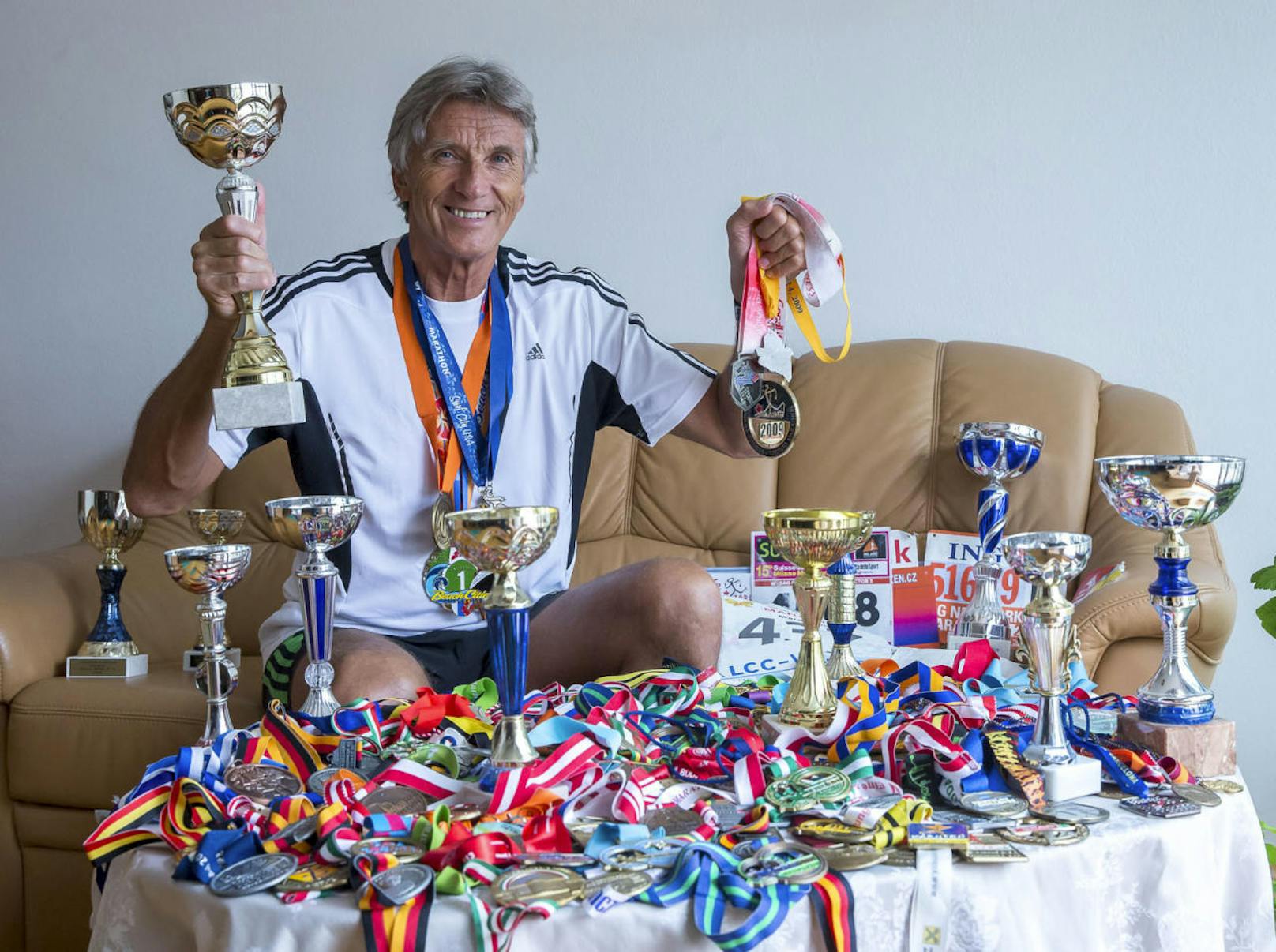 Mehr als 300 Medaillen, dazu Pokale und Startnummern hat er auf seinem Wohnzimmertisch in Wien-Simmering ausgebreitet. "Ich bin schon in 53 Ländern gelaufen. Weitere sechs Nationen will ich noch heuer bereisen."