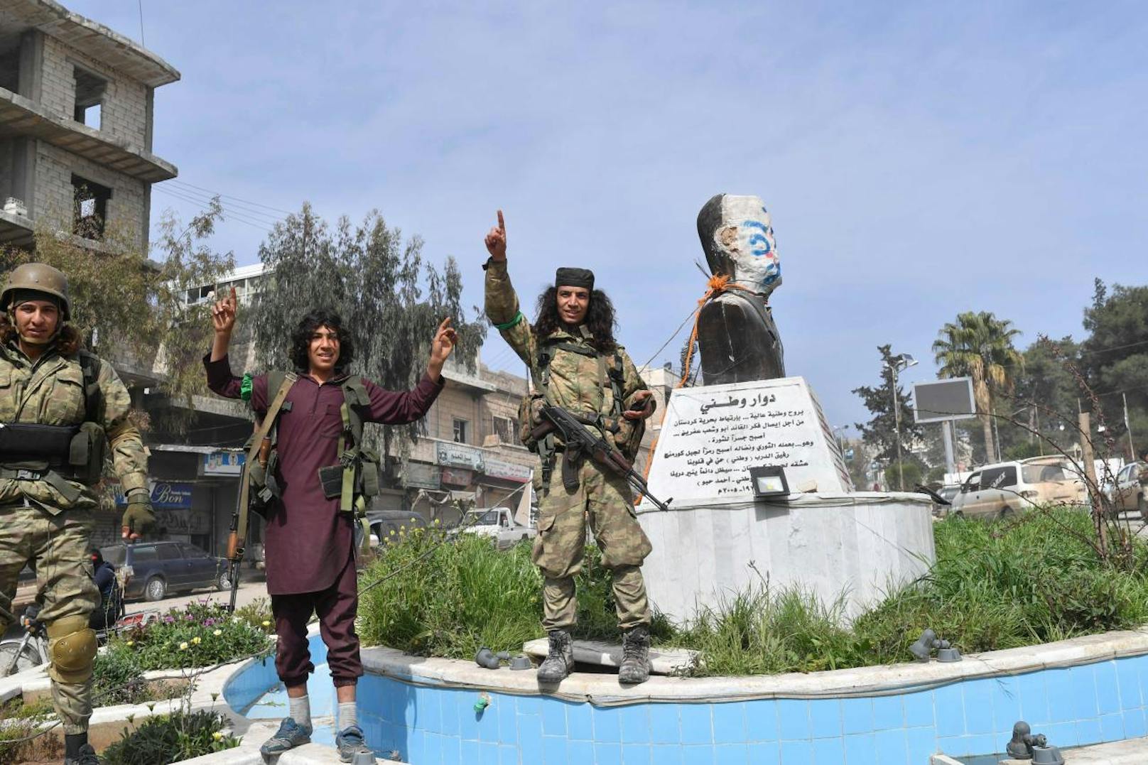 Nach der Eroberung von Afrin marschierten syrische Rebellenkämpfer in Afrin ein und plünderten. Viele der Rebellen zeigen unverhohlen den islamistischen Finger nach oben, eine Geste, die auch typisch für IS-Dschihadisten ist. Mit ihren langen Haaren und Bärten sowie den martialischen Messern erinnern die Kämpfer weniger an die Rebellen der "Freien Syrischen Armee" (FSA), deren Titel sie kapern, sondern an Dschihadisten diverser islamistischer Milizen.