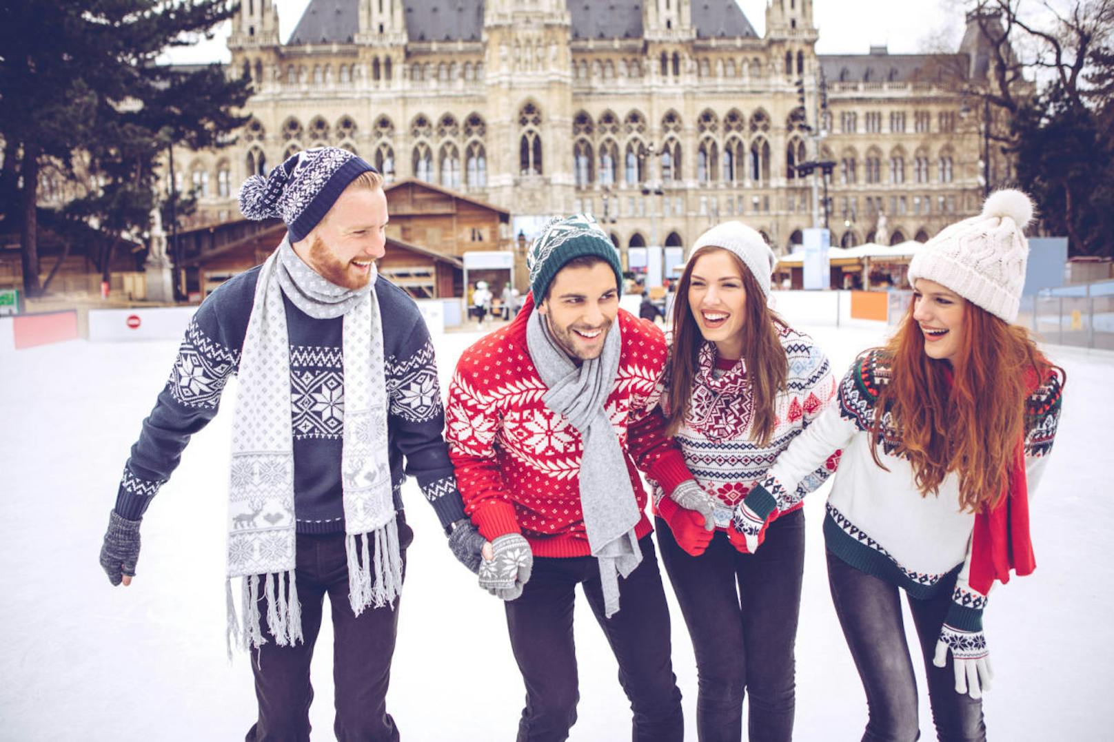 Friends having so much fun while ice skating. Wearing warm clothing.