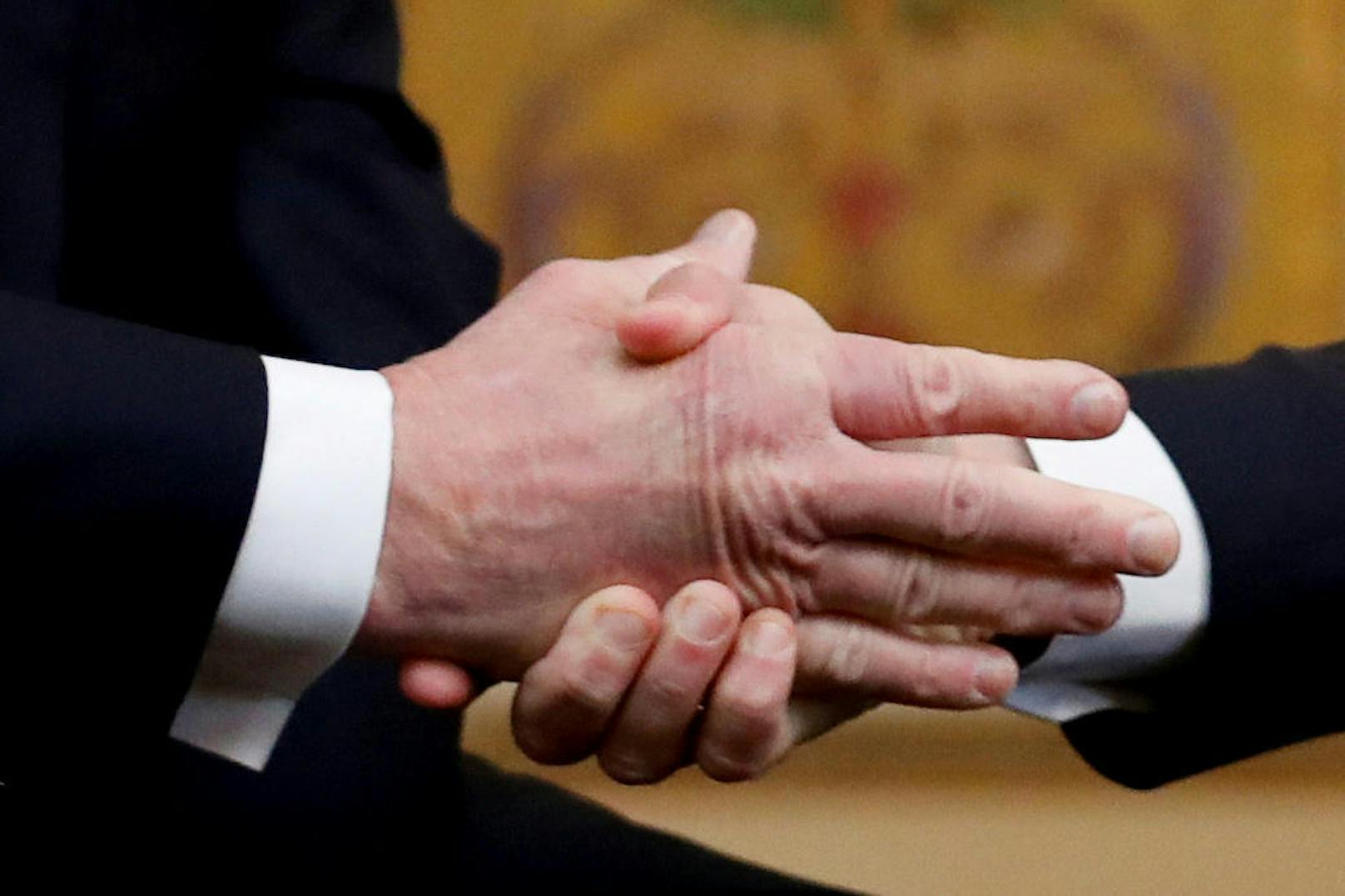Eisern umklammert Emmanuel Macron beim Treffen in Paris die Hand von US-Präsident Trump.