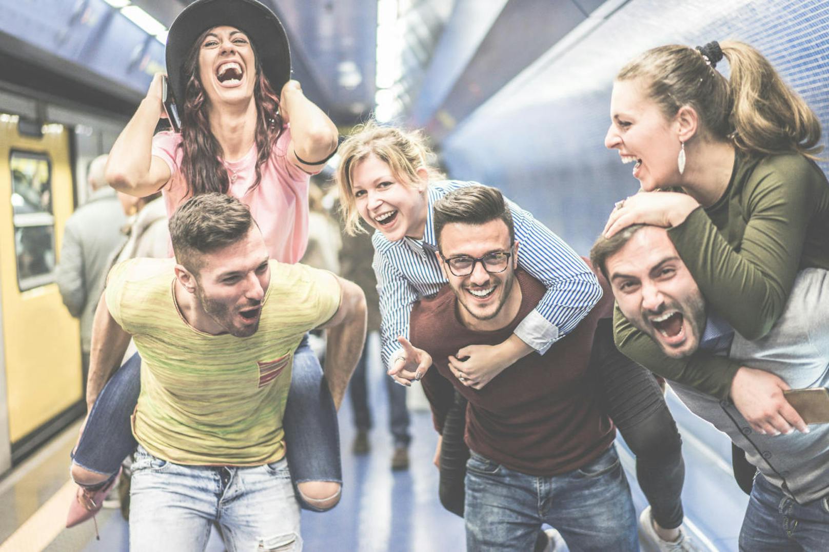 Group of party friends having fun in underground metropolitan station - Young people ready for night out  - Friendship and party concept - Warm desaturated filter - Focus on center man face glasses