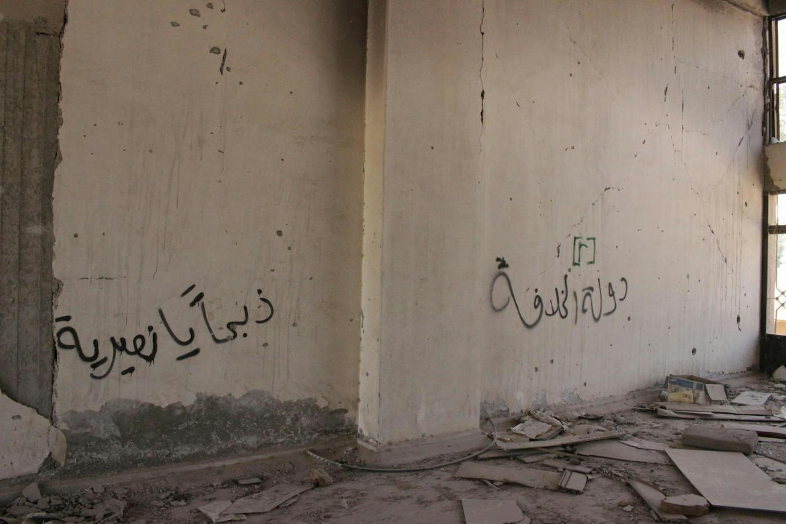 Graffitis in den Gängen des Stadions machen deutlich, wer hier wie regierte: "Der Staat des Kalifats" (rechts), "Wir kommen, um euch Alawiten zu köpfen" (links).
