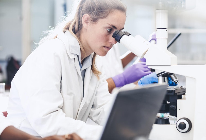 Scientist Looking into the Microscope
