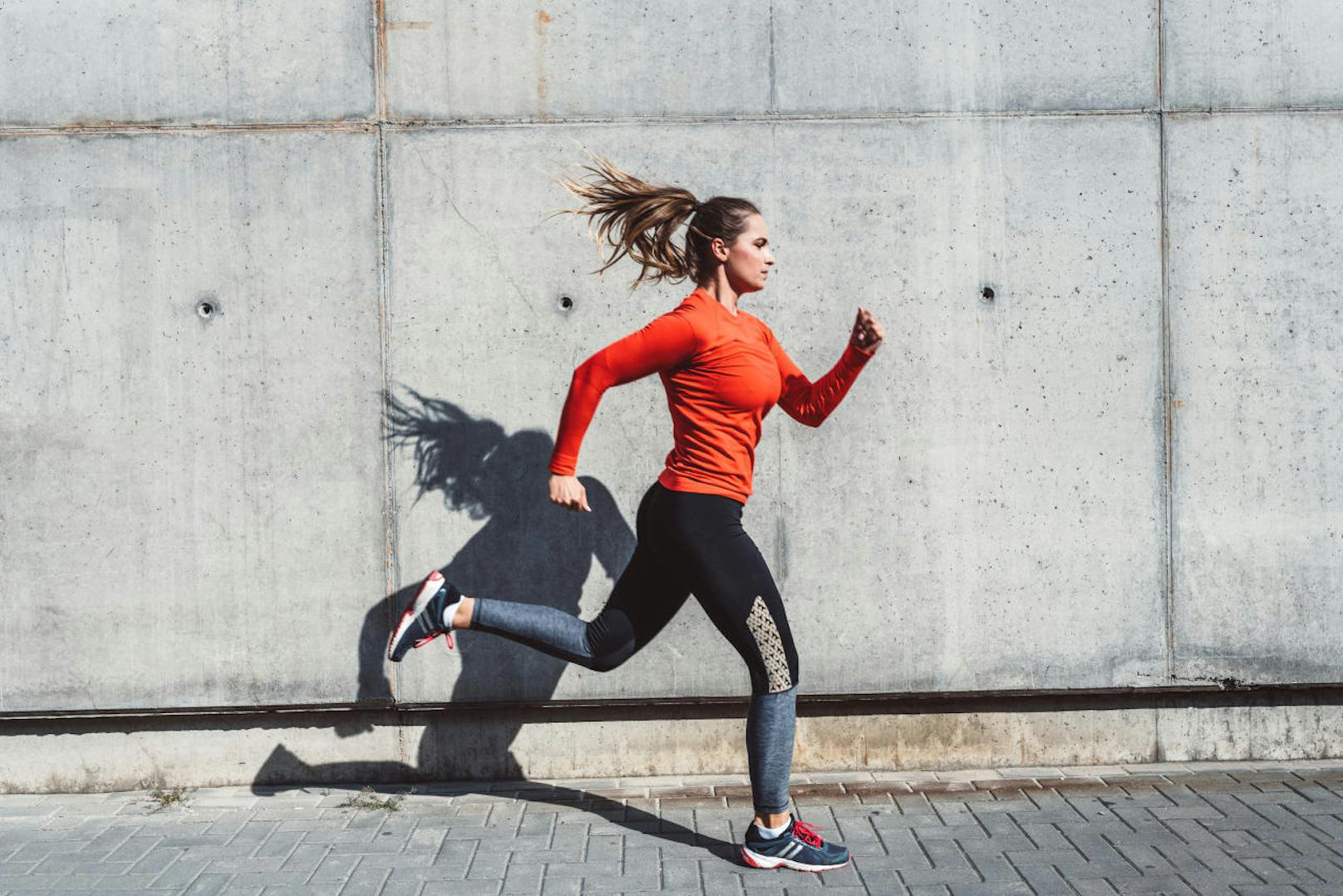 Woman in jogging outfit running outdoors.