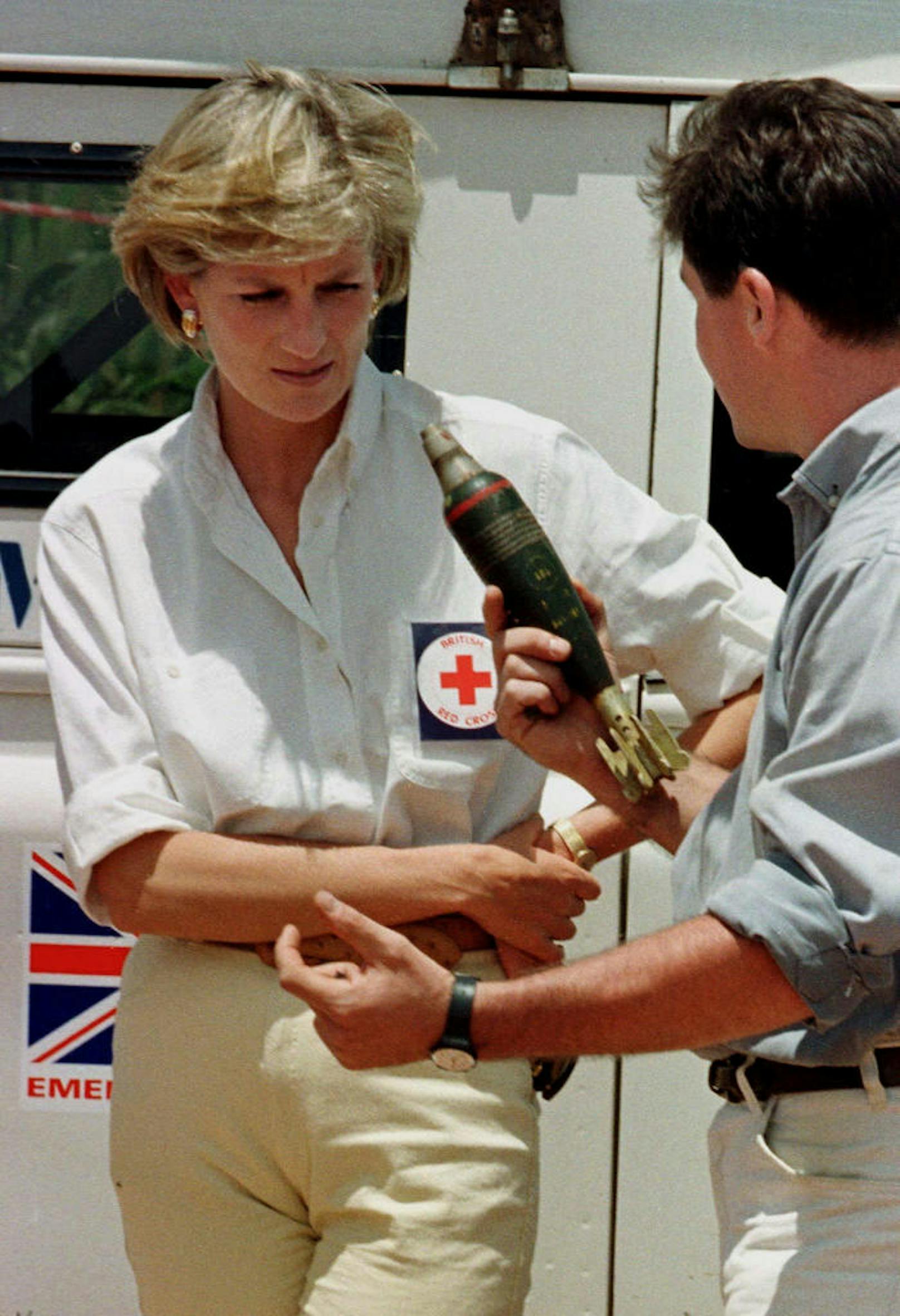 Vier Tage besuchte die Prinzessin das Landminenfeld in Huambo. Der Rot-Kreuz-Mitarbeiter erklärt Diana die Zerstörungskraft einer Granate. 