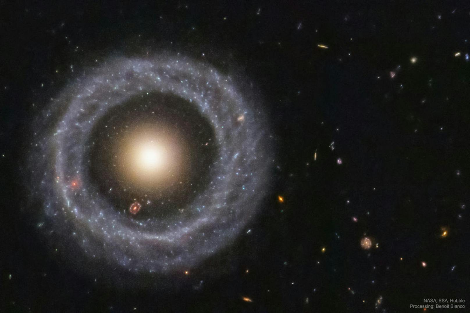 ... dass im Inneren der Ringgalaxie eine weitere rötliche Ringgalaxie zu sein scheint. Diese ist aber kein Teil von ihr, sondern befindet sich noch einmal Millionen Lichtjahre weiter entfernt.