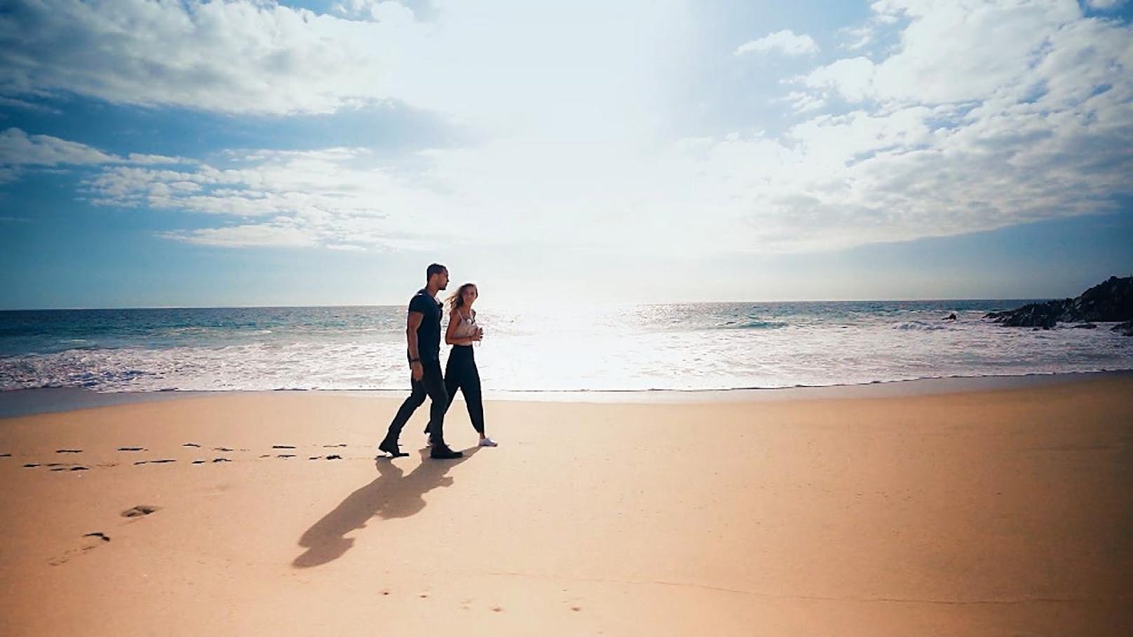 Andrej und Kimberley lassen sich beim gemeinsamen Strandspaziergang vom Meeresrauschen einlullen