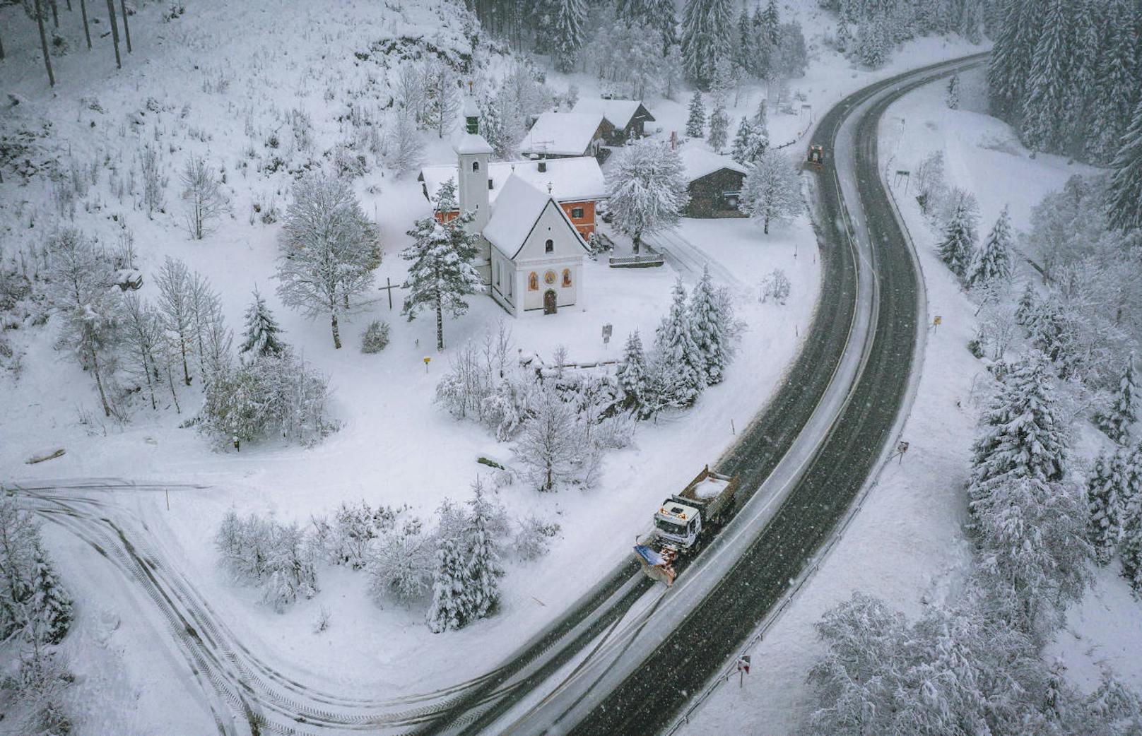 Ein Schneepflug der Straßenmeisterei räumt die mit Schnee bedeckte Fahrbahn am Pass Thurn.