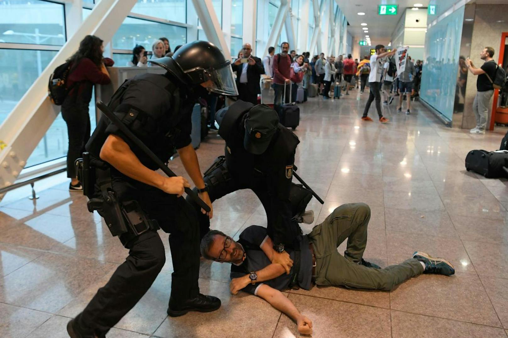 Download von www.picturedesk.com am 14.10.2019 (18:48). 
Spanish policemen grab a protester inside El Prat airport in Barcelona on October 14, 2019 as thousands of angry protesters took to the streets after Spain's Supreme Court sentenced nine Catalan separatist leaders to between nine and 13 years in jail for sedition over the failed 2017 independence bid. - As the news broke, demonstrators turned out en masse, blocking streets in Barcelona and elsewhere as police braced for what activists said would be a mass response of civil disobedience. (Photo by LLUIS GENE / AFP) - 20191014_PD6876 - Rechteinfo: Nur für redaktionelle Nutzung! - Editorial Use Only! Werbliche Nutzung nur nach Freigabe!