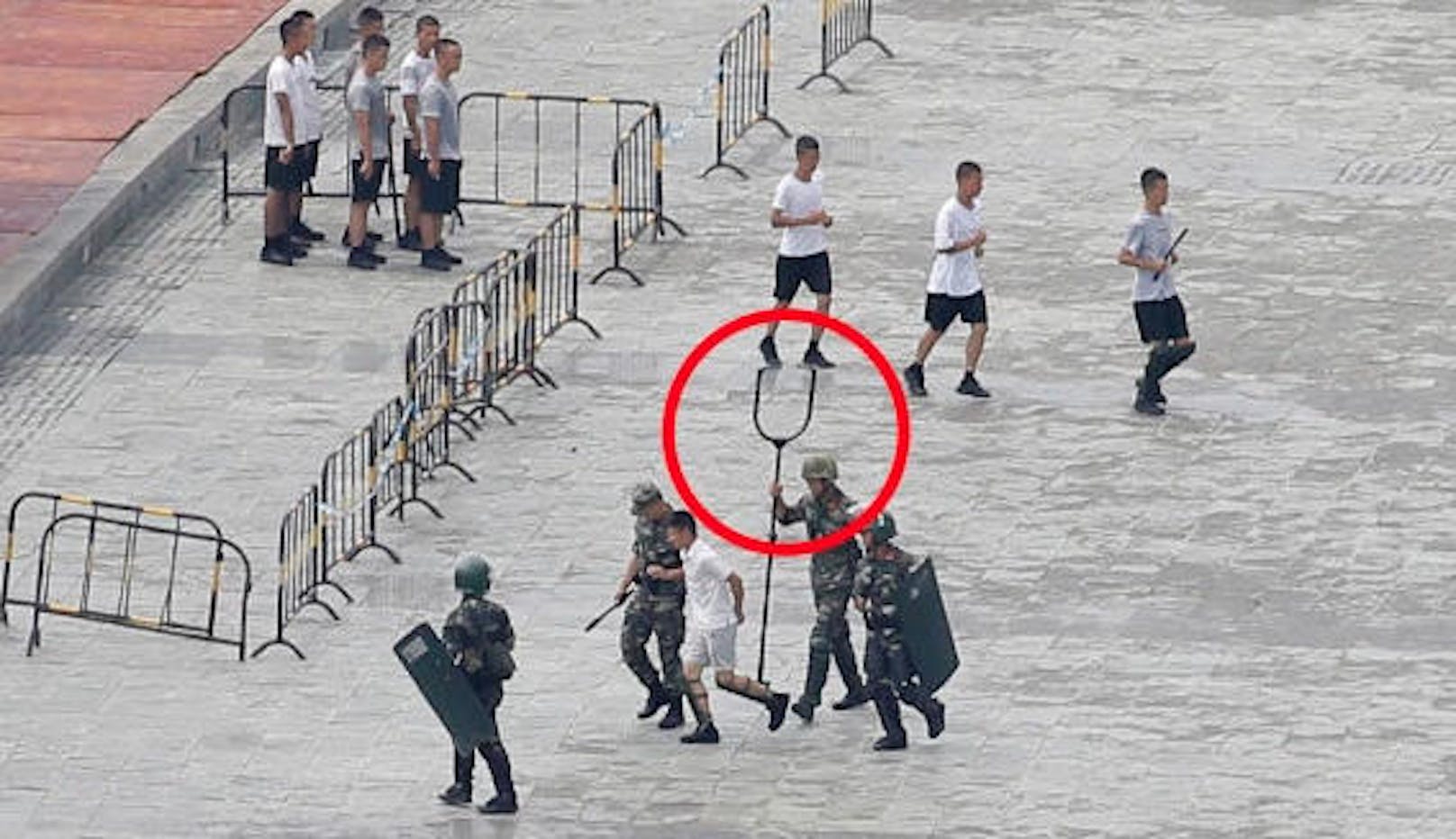 China-Soldaten üben währenddessen mit Elektroschock-Gabeln.