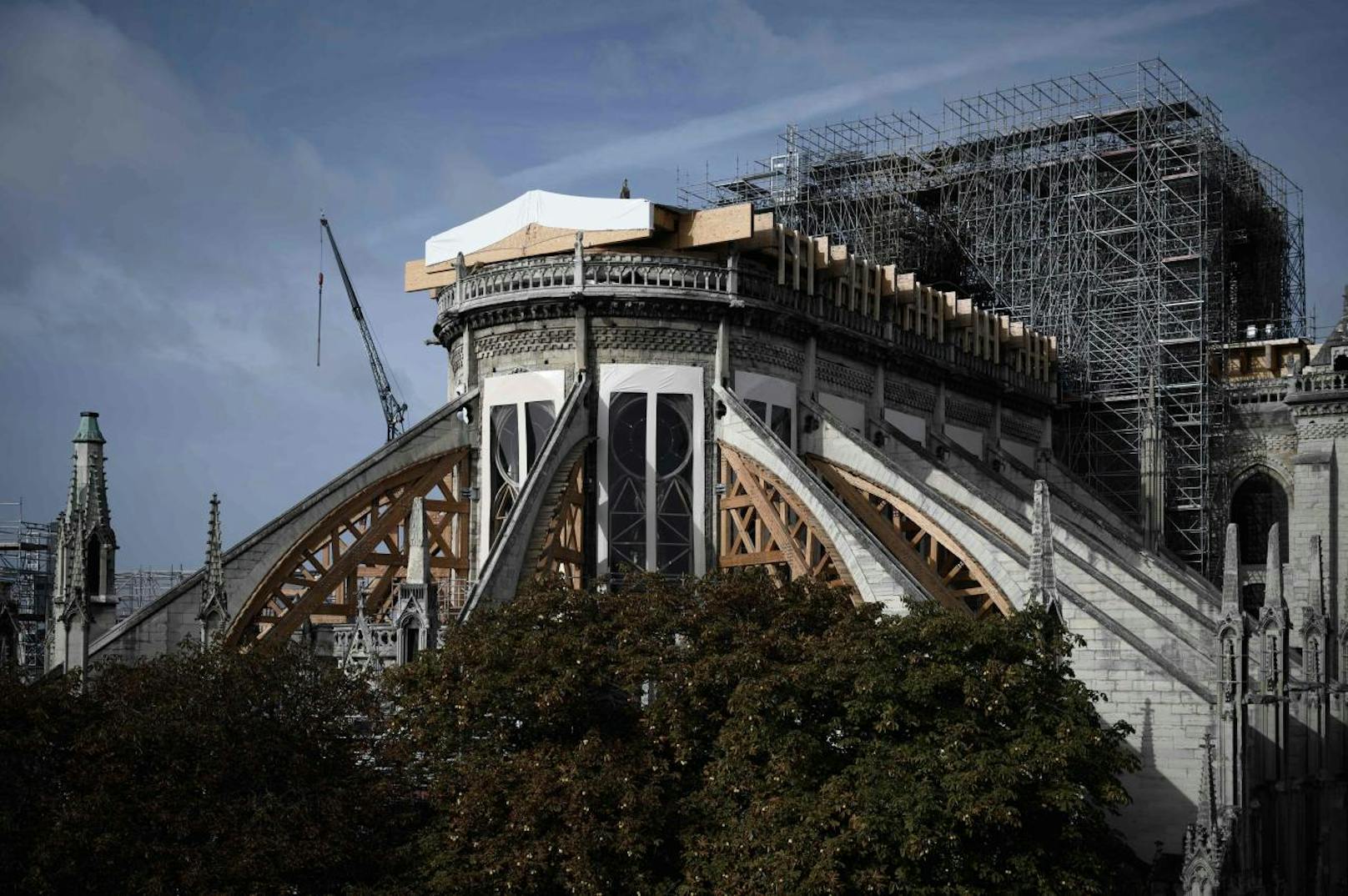 Eine abenteuerlich verbogene, 500 Tonnen schwere Stahlkonstruktion klammert sich über den in Rauch aufgegangenen Dachstuhl der Pariser Kathedrale Notre-Dame