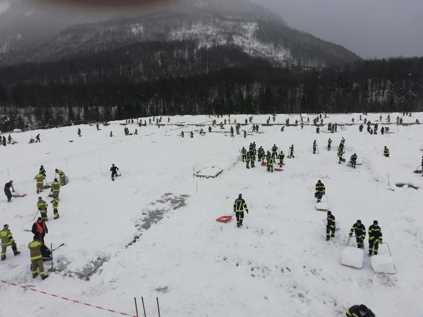 Zahlreiche Feuerwehrmänner befreiten in Ebensee ein Hallendach von 24.000m³ Schnee.