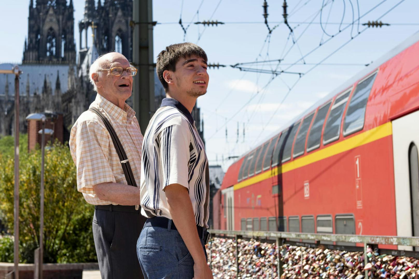 Toni (Ivo Kortlang) schaut sich mit seinem Opa (Dieter Schaad) Züge an.