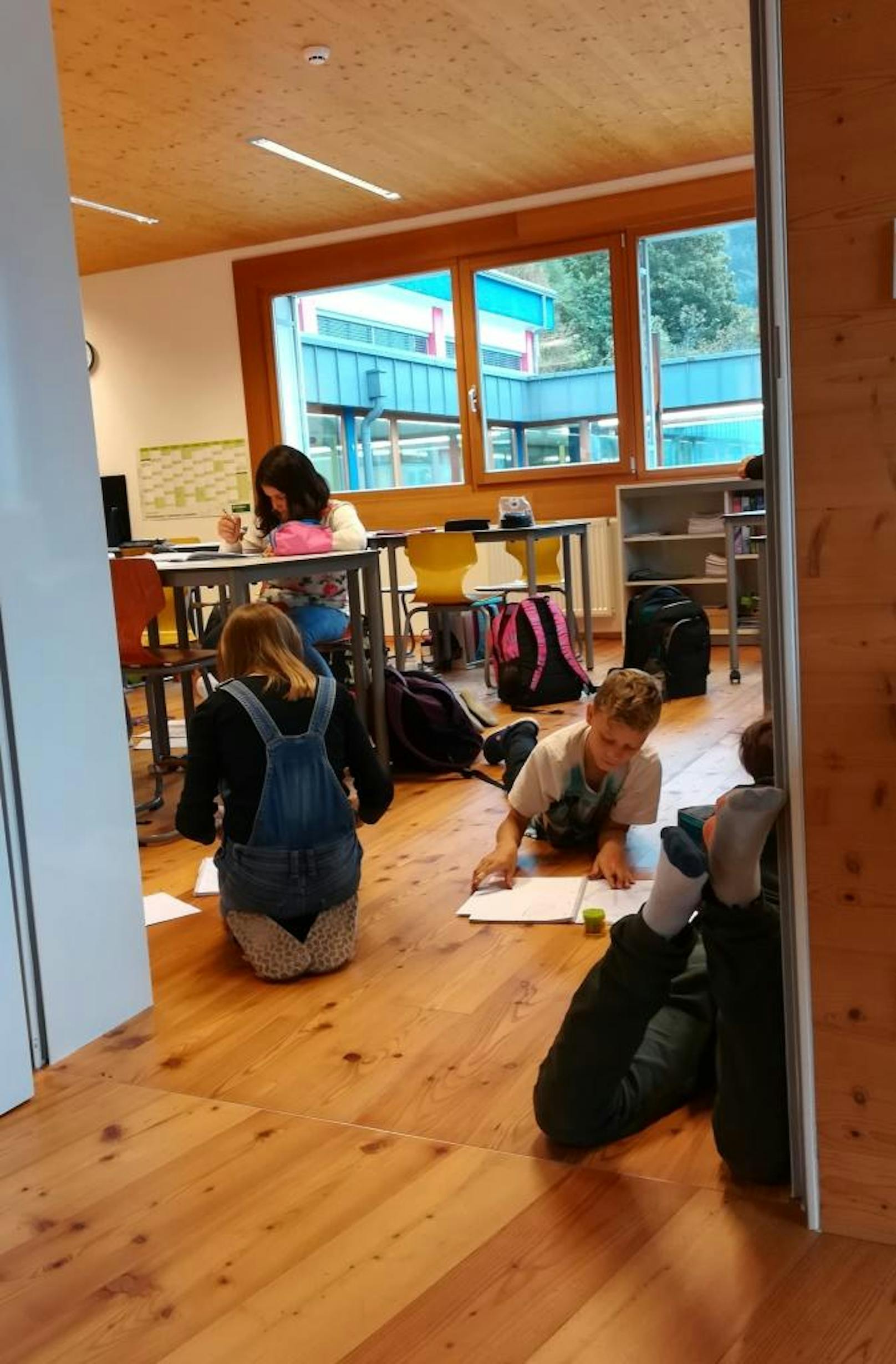 Ein Blick ins Klassenzimmer zeigt: Manche Schüler arbeiten lieber im Sitzen, manche lieber am Boden.
