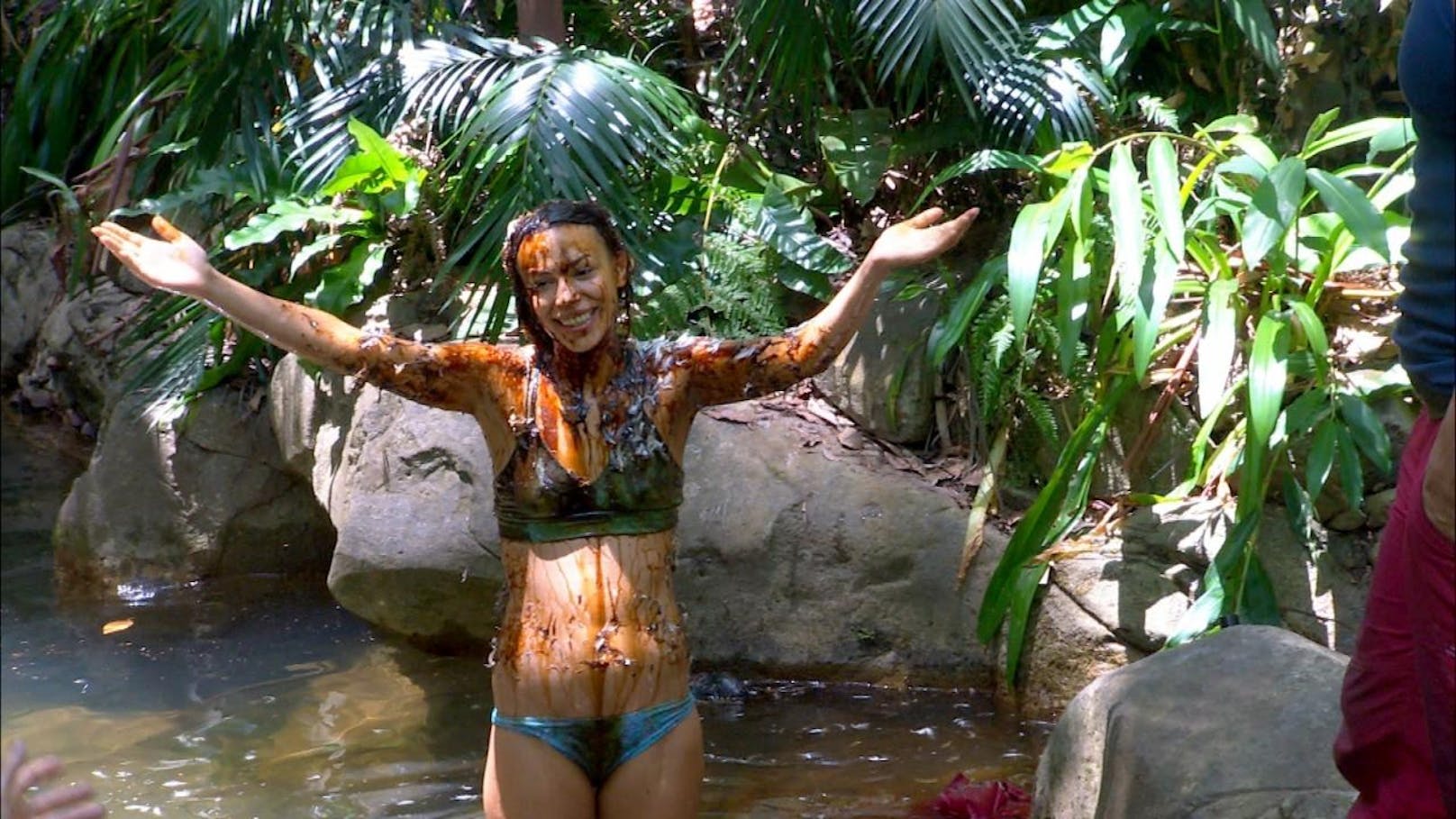 Geteert und gefedert kehrt Gisele Oppermann nach ihrer erfolgreichen Dschungelprüfung stolz ins Camp zurück und wäscht sich im Teich.