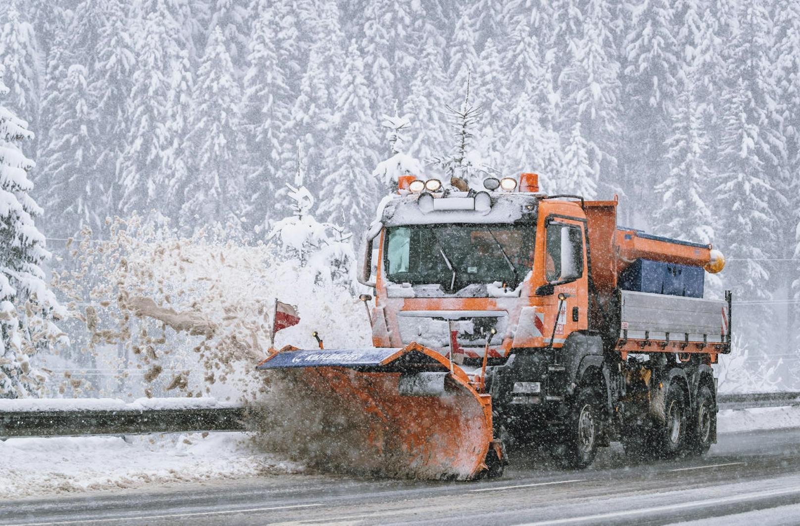 Ein Fahrzeug der Straßenmeisterei räumt die mit Schnee bedeckte Fahrbahn am Pass Thurn.