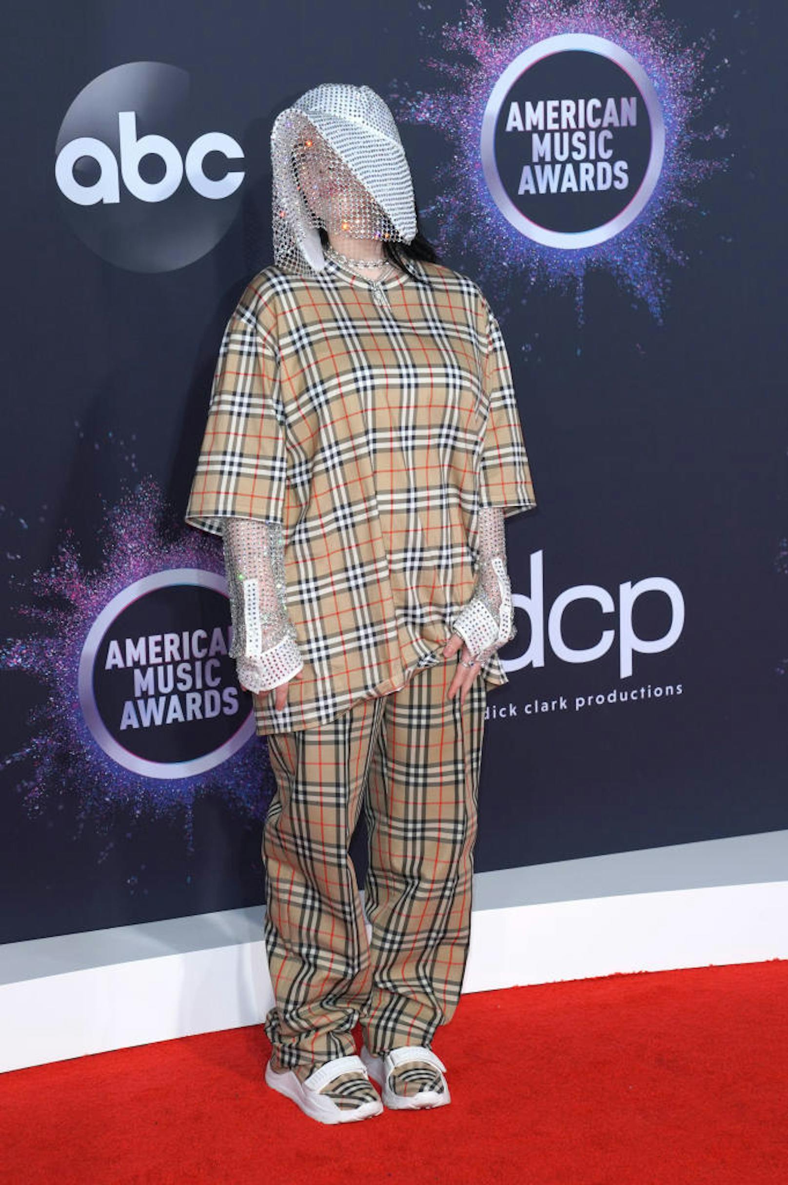 Der bekannte, sympathische Gruselfaktor bei Billie Eilish, der sogar vergessen lassen könnte, dass hier die Mutation eines Sacks und eines Pyjamas zur Schau gestellt wird. Diese "Kreation" ist übrigens von Burberry, für die Kauffreudigen.