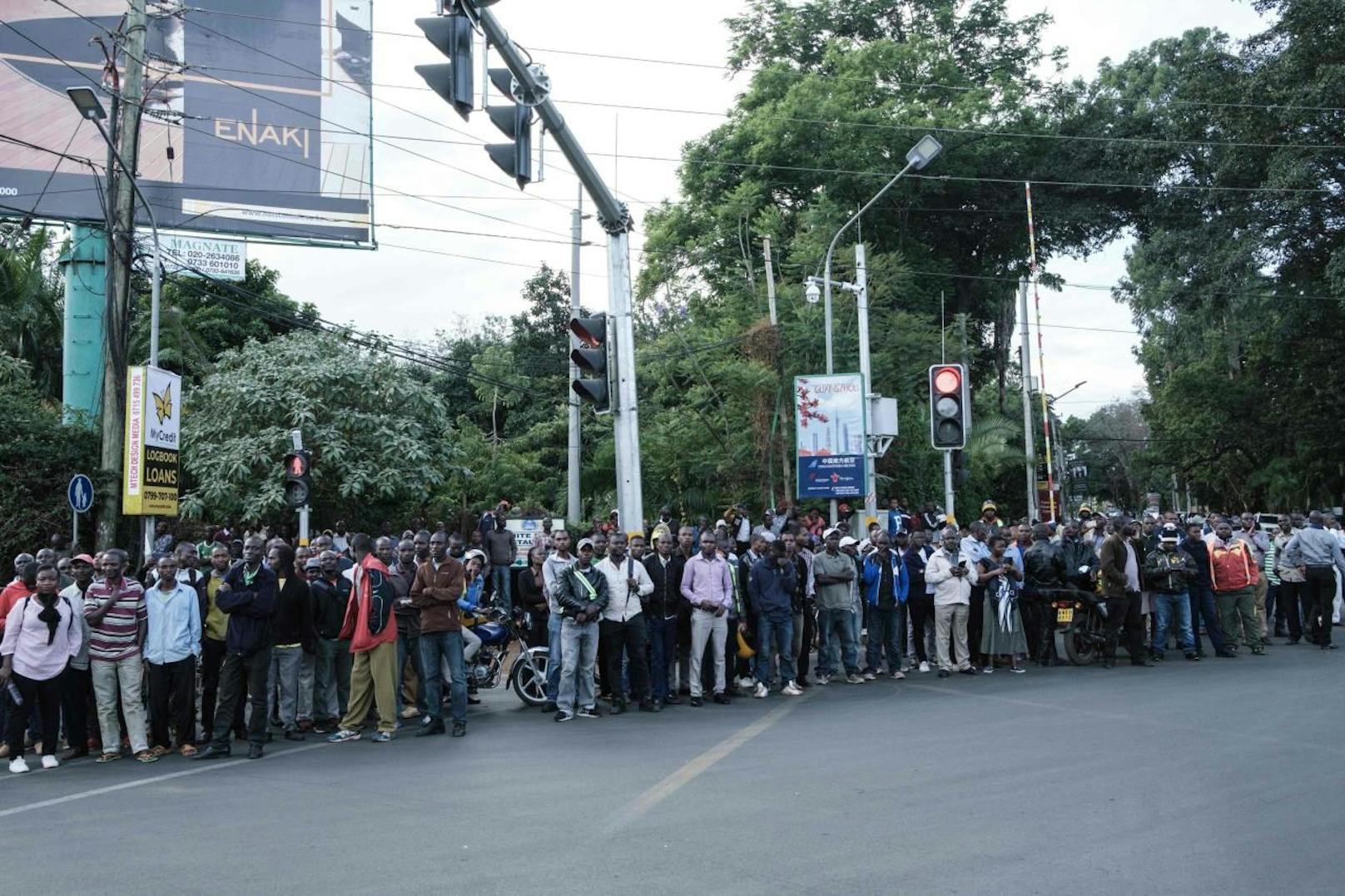 Download von www.picturedesk.com am 16.01.2019 (06:05). 
People gather at a road block point settled by the police after a blast followed by a gun battle rocked a upmarket hotel complex in Nairobi on January 15, 2019. - At least five people were killed on January 15 when an Islamist suicide bomber and gunmen stormed an upmarket hotel complex in Nairobi, in the first such attack in the Kenyan capital in five years. (Photo by Yasuyoshi CHIBA / AFP) - 20190115_PD8489 - Rechteinfo: Nur für redaktionelle Nutzung! - Editorial Use Only! Werbliche Nutzung nur nach Freigabe!
