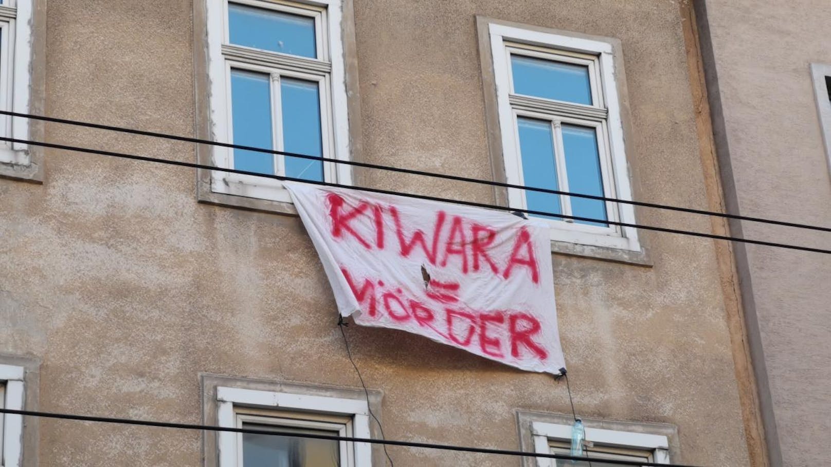 Beim Lokalaugenschein in der Früh scheint sich die Behauptung zu bewahrheiten: Das heruntergekommene Haus in Wien-Hernals ist mit Transparenten verhängt, auf denen Parolen wie "Kiwara = Mörder" gemalt sind.