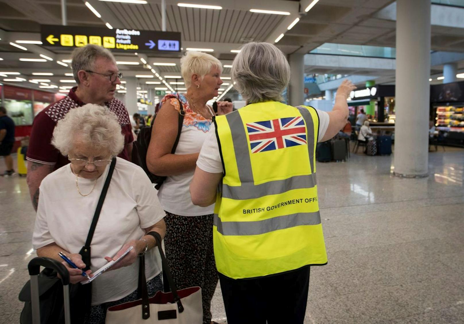 Eine britische Regierungsbeamte spricht mit britischen Reisegästen der insolventen Agentur Thomas Cook am Flughafen von Palma de Mallorca.