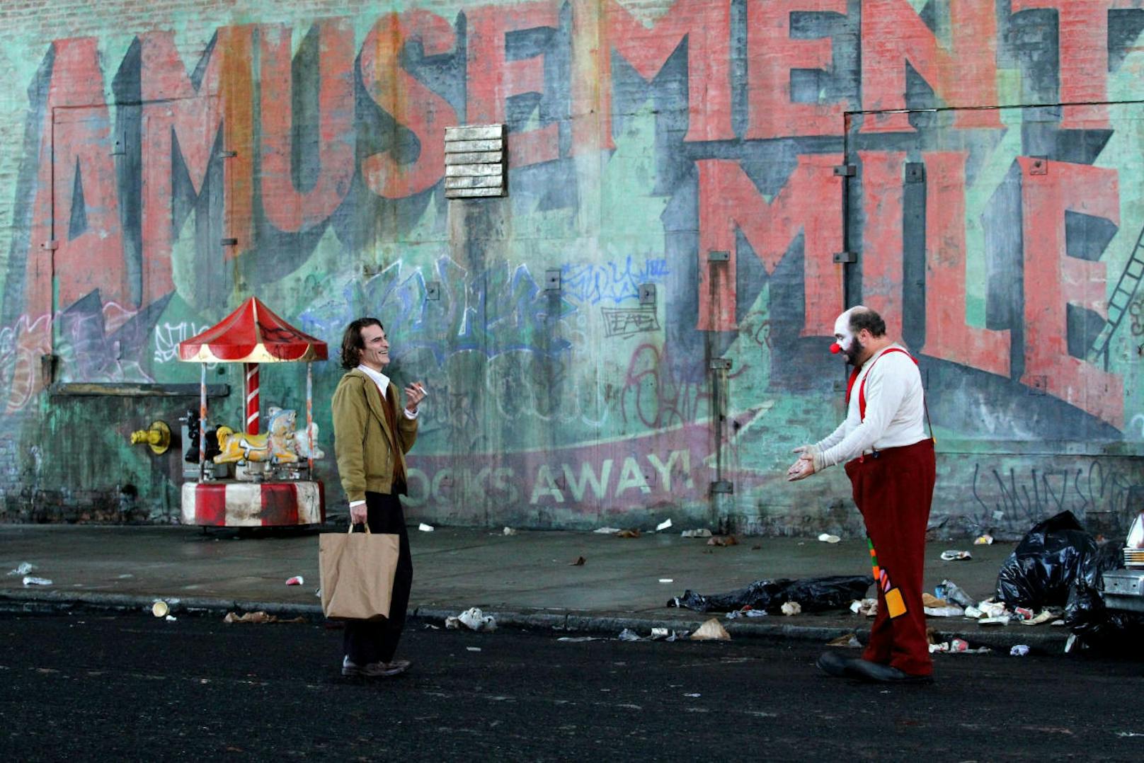 Für die Dreharbeiten von "Joker" wurde Harlem in den Gothamer Stadtteil "Amusement Mile" verwandelt. Der Name verweist auf einen abgewrackten Vergnügungspark in Alan Moores "The Killing Joke", in dem der Joker sein Quartier aufschlägt.