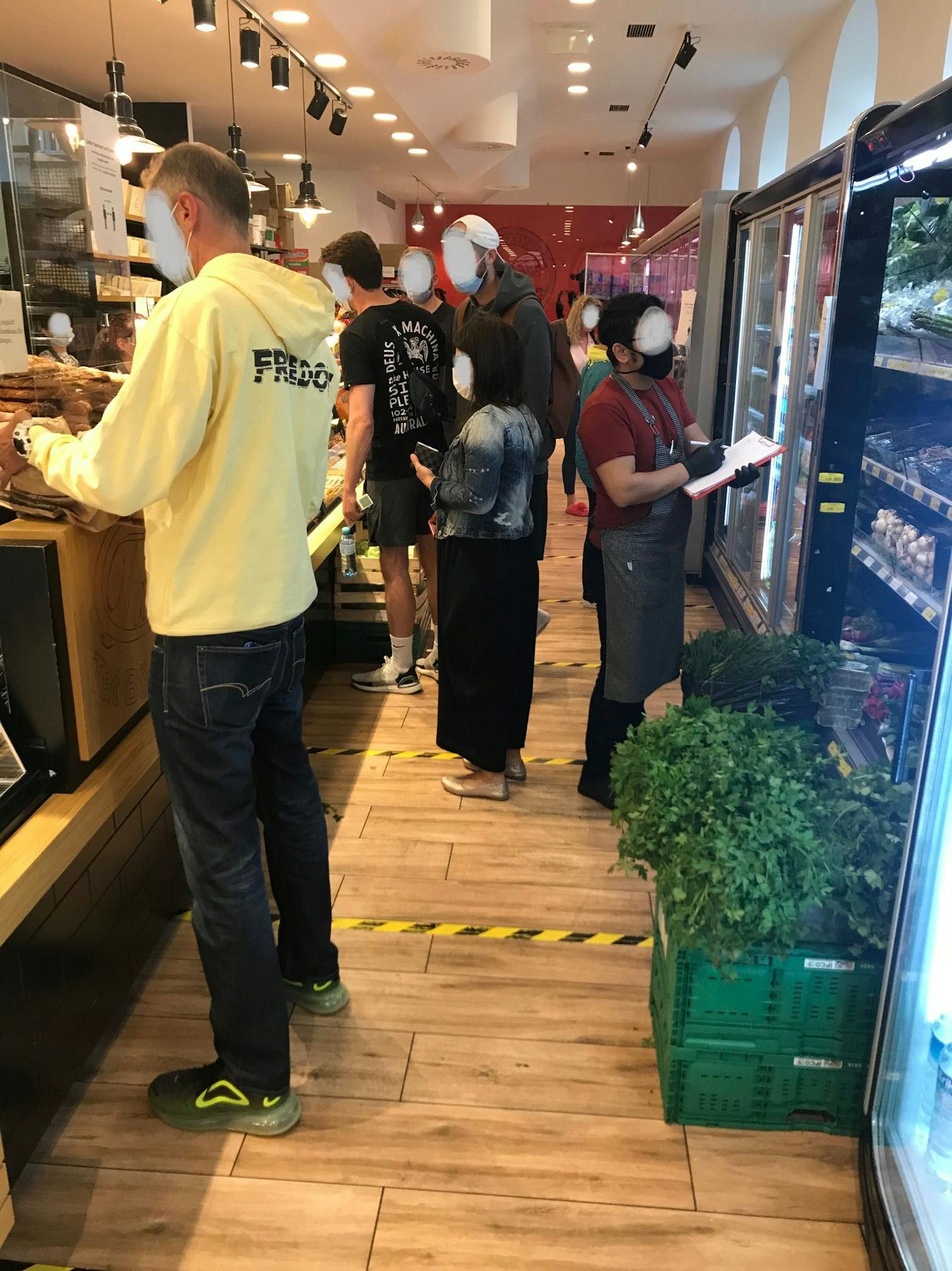 Kunden drängen sich in den Mini-Supermarkt, darunter viele ohne Mund-Nasen-Schutz. Trotz Abstandskleber wird die Sicherheitsmaßnahme ignoriert.