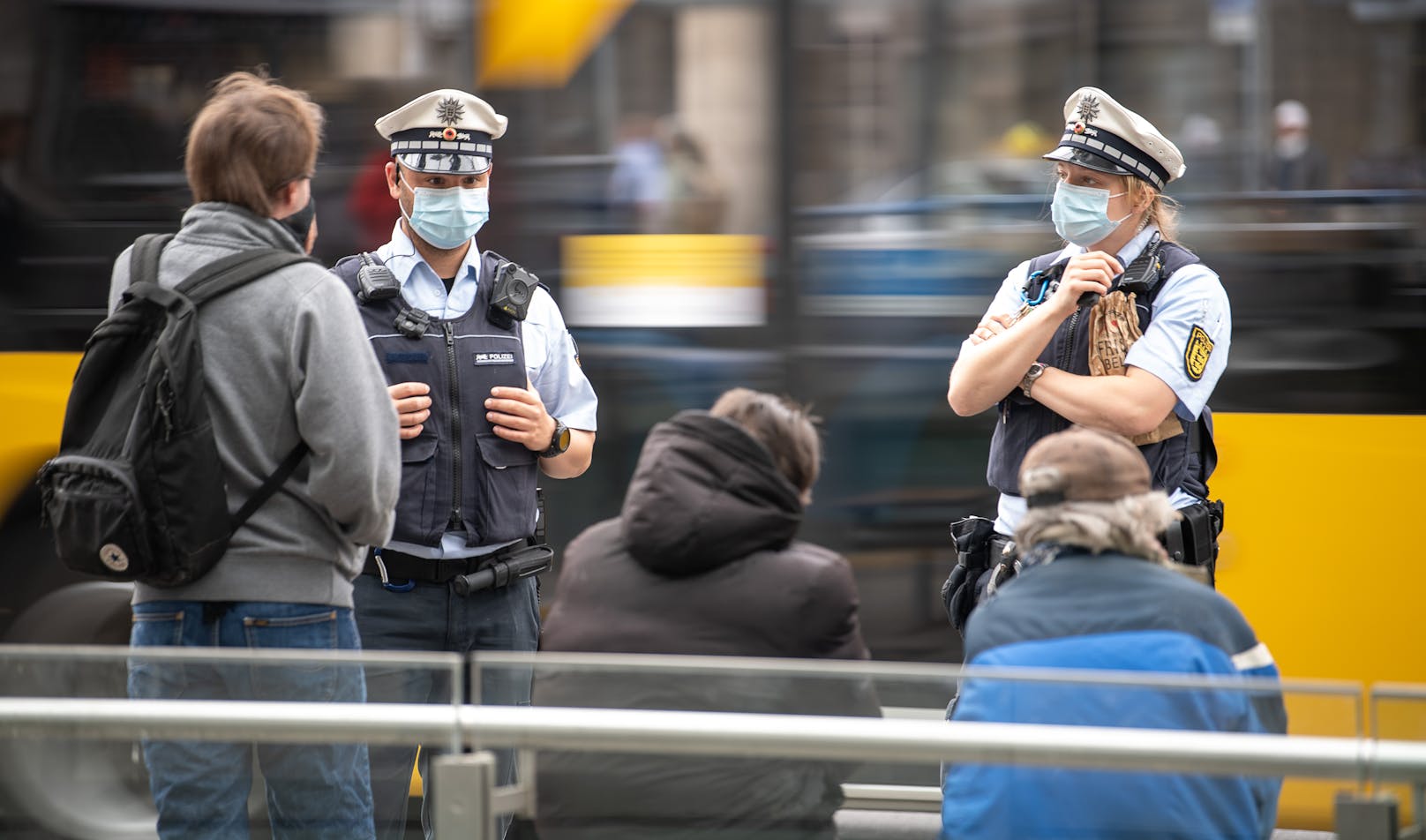 Polizisten sprechen drei junge Männer an einer Tram-Station in Stuttgart an. Symbolfoto