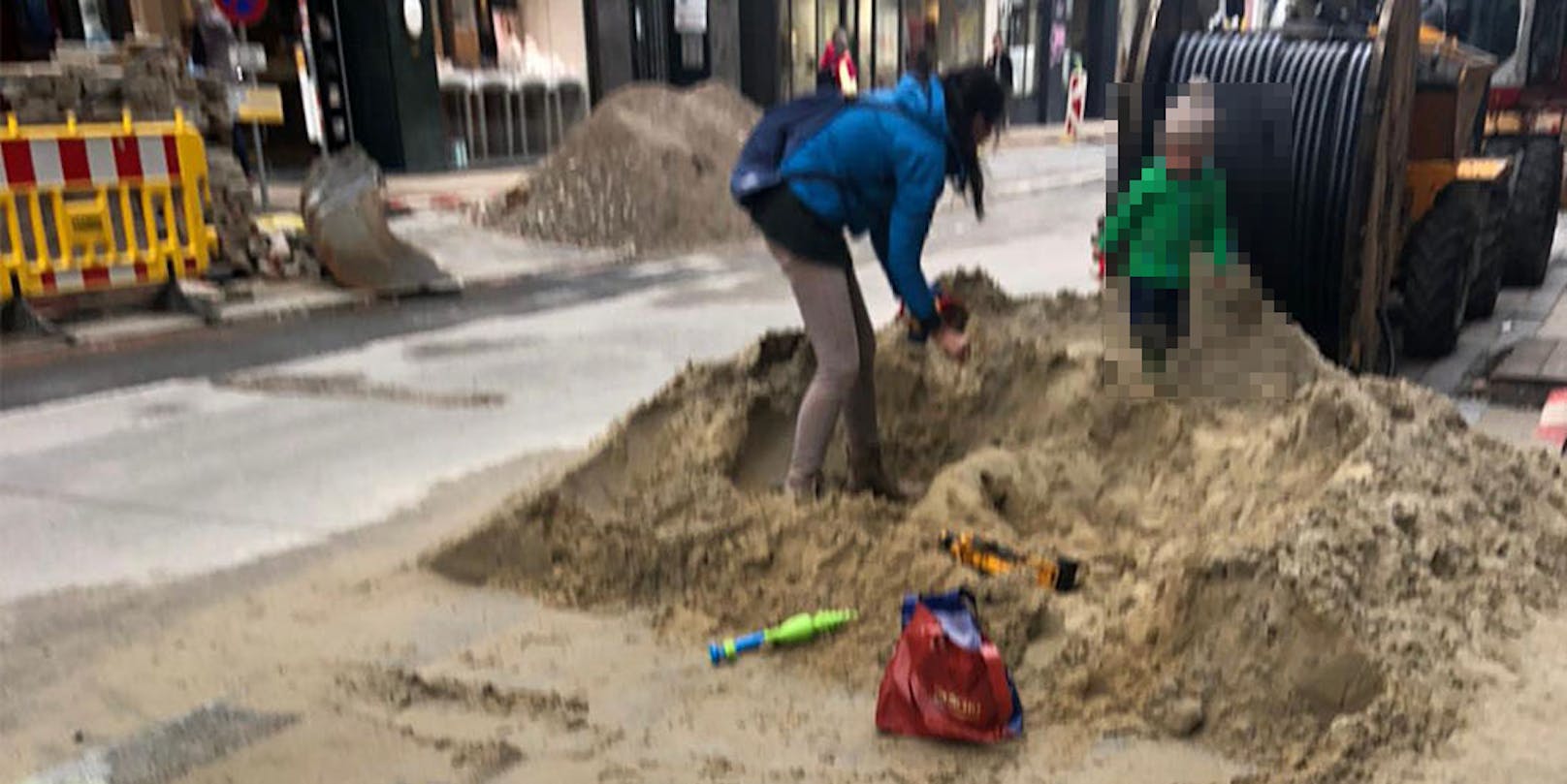 Eine Frau und ihr Kind nutzen die Baustelle in der Neubaugasse als Spielplatz