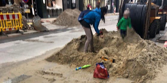 Eine Frau und ihr Kind nutzen die Baustelle in der Neubaugasse als Spielplatz