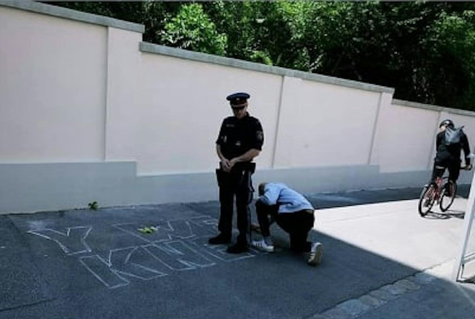 Vor Wiener US-Botschaft: Polizist gegen Kreide-Maler