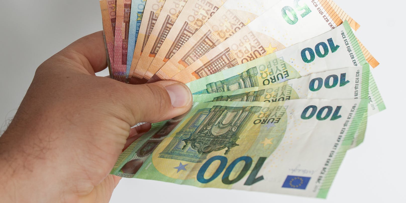 Ein Mann hält Euro-Geldscheine in der Hand. Symbolbild