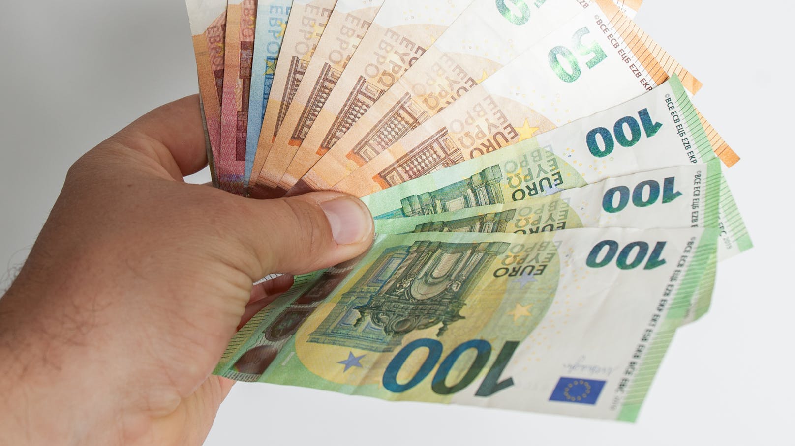 Ein Mann hält Euro-Geldscheine in der Hand. Symbolbild