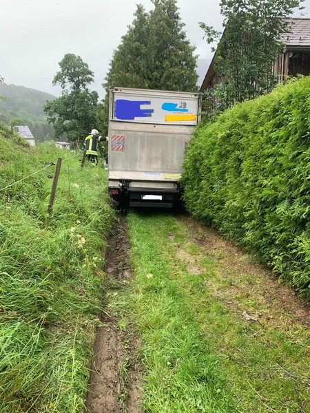 Das Fahrzeug blieb zwischen einer Gartenmauer und einer Böschung stecken