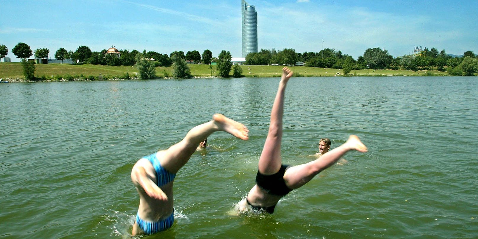 Jugendliche erfrischen sich mit einem Sprung ins kühle Nass der Neuen Donau in Wien
