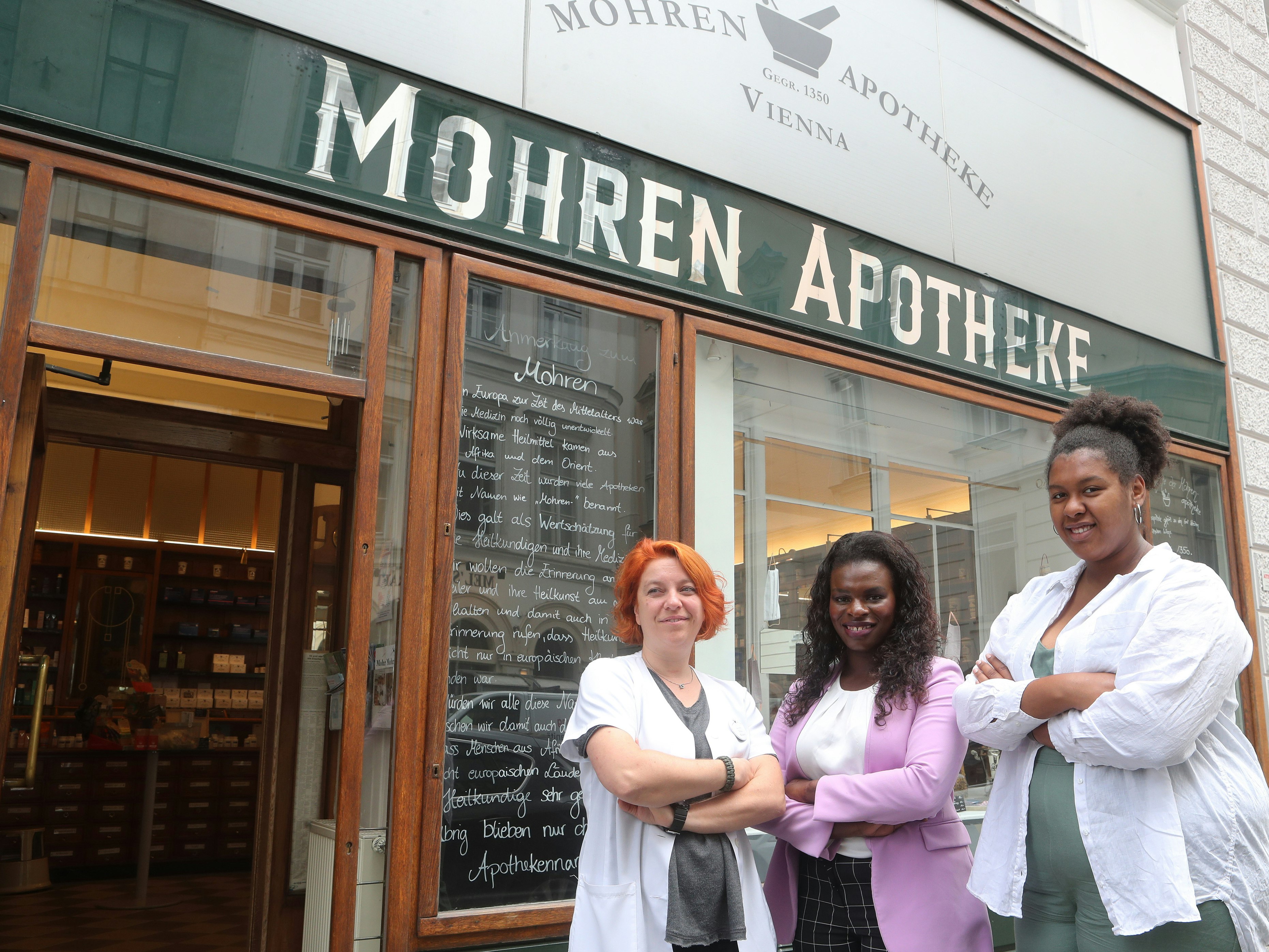 Auch in Wien gab es eine heftige Debatte. Im Bild: Apothekerin Sassa Marosi mit den Black-Lives-Matter-Organisatorinnen Mireille Ngosso und Noomi Anyanwu (re.) – trotz Ankündigung im Jahr 2020 heißt die Apotheke noch heute so. Dafür gibt es eine <a rel="nofollow" href="https://mohrenapo.at/pages/geschichte">ausführliche Erklärung zur Entstehung des Namens</a>.