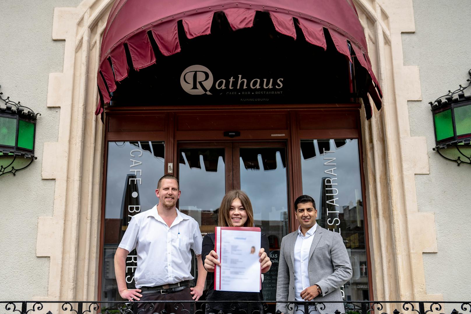 Bei ihrer neuen Lehrstelle: Samantha T. mit Rathaus-Café-Besitzer Martina Schödl und Gewerkschafter Sumit Kumar