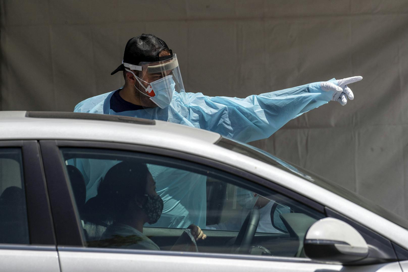 Ein Mitarbeiter einer Drive-In Corona-Teststation in Lake View Terrace, Kalifornien, erteilt am 30. Juni 2020 einer Autofahrerin Anweisungen