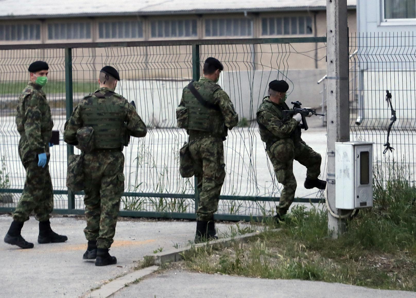 Kroatische Grenzpolizisten patrouillieren um ein Flüchtlingscamp.