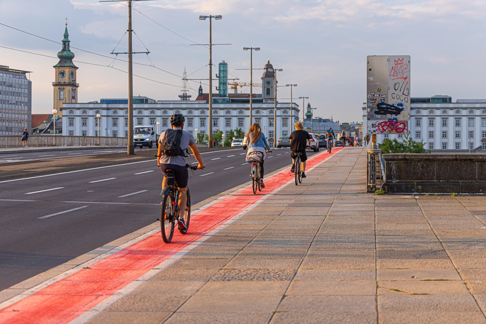 Die ersten Radfahrer fahren schon am roten Radweg.