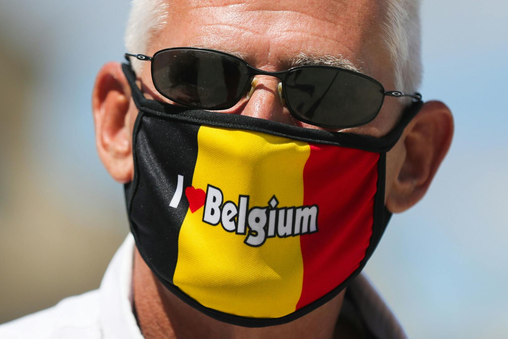 Ein Mann mit Schutzmaske in den belgischen Landesfarben