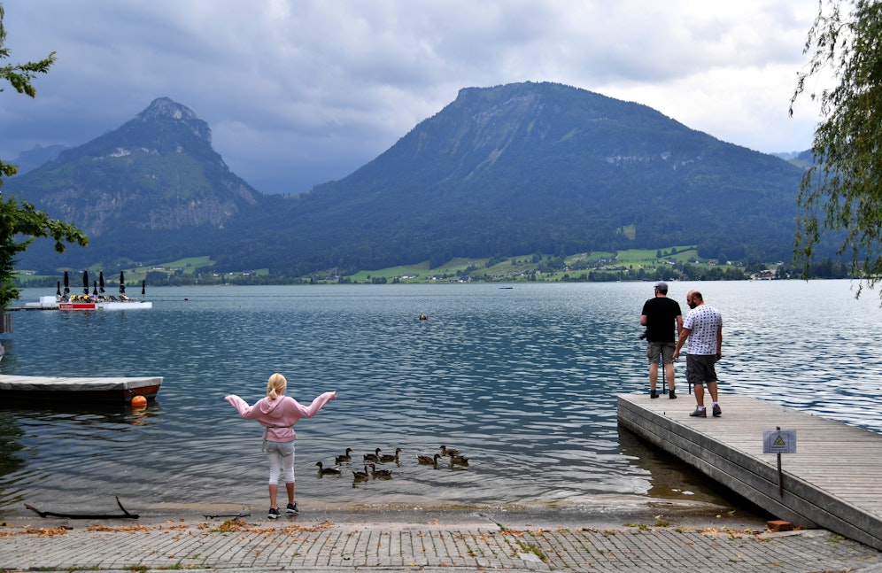 Urlauber an einem Ufer des Wolfgangsees am Freitag, 24. Juli 2020, in St. Wolfgang