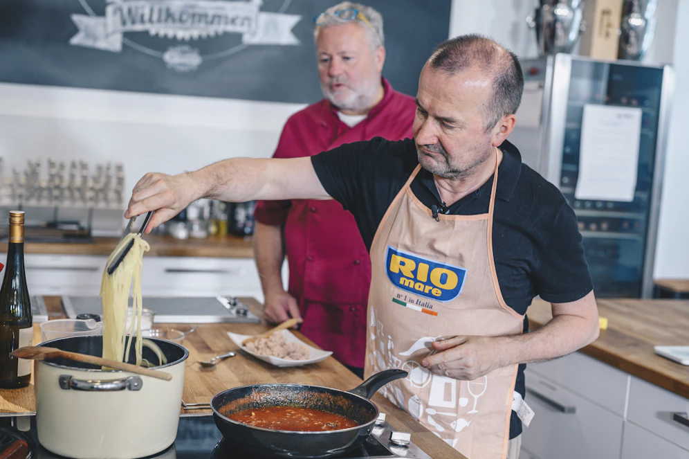 Profi-Koch Erik Pauer (li.) und Gewinner Konrad S. (re.) bereiten gemeinsam Konrads Lieblingsrezept - Linguine all'arrabbiata - mit Rio Mare Thunfisch Natura zu.