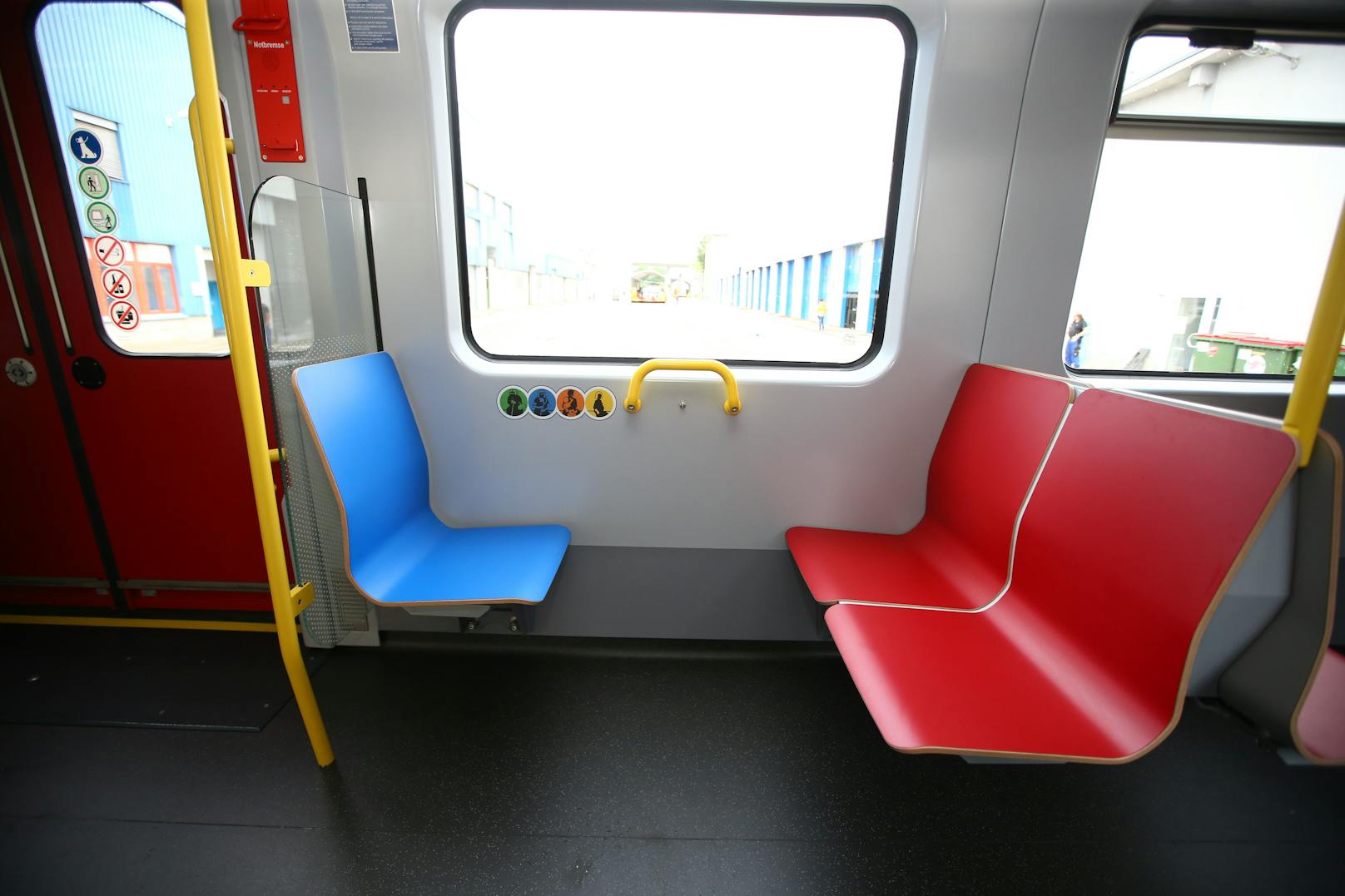 Die Sitze in blauer Farbe kennzeichnen einen Priority-Sitz und sind für Fahrgäste mit eingeschränkter Mobilität vorgesehen.