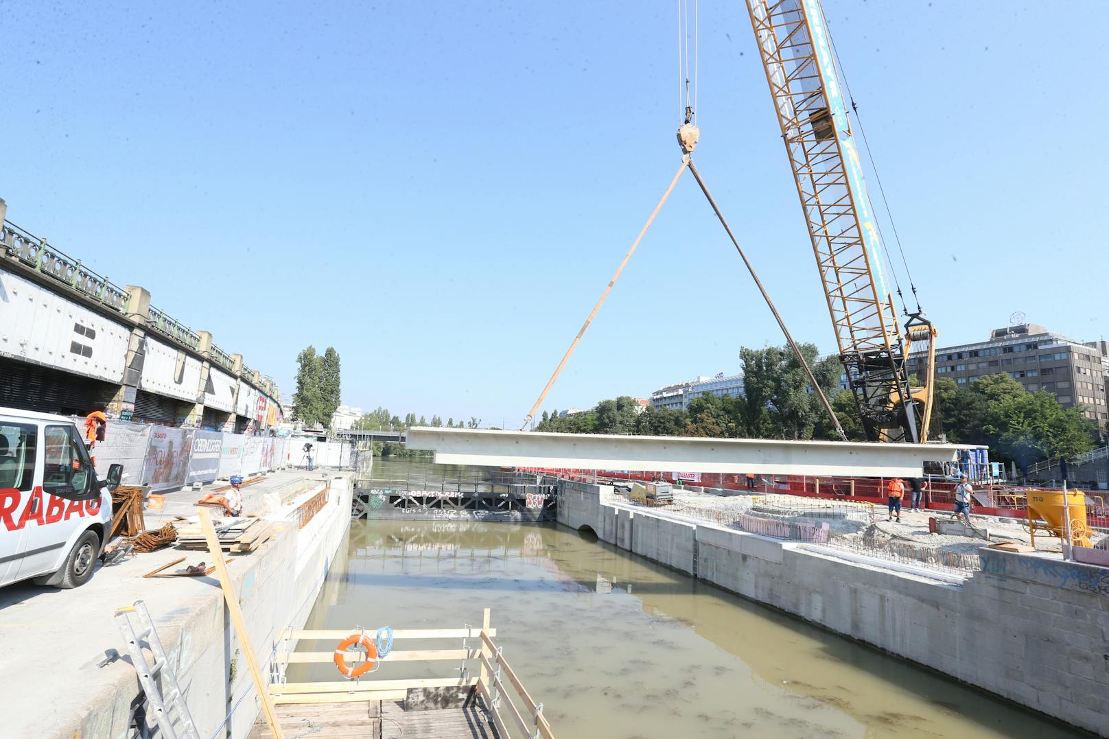 Im Zuge der Bauarbeiten für die Schwimmenden Gärten am Wiener Donaukanal wurden am Montag Brückenbauteile mit einem Großraumschubleichter über den Donaukanal angeliefert und per Kran an den Kai bzw. die Kaiserbadschleuse versetzt. Am Mittwoch kommt die zweite "Fuhre".